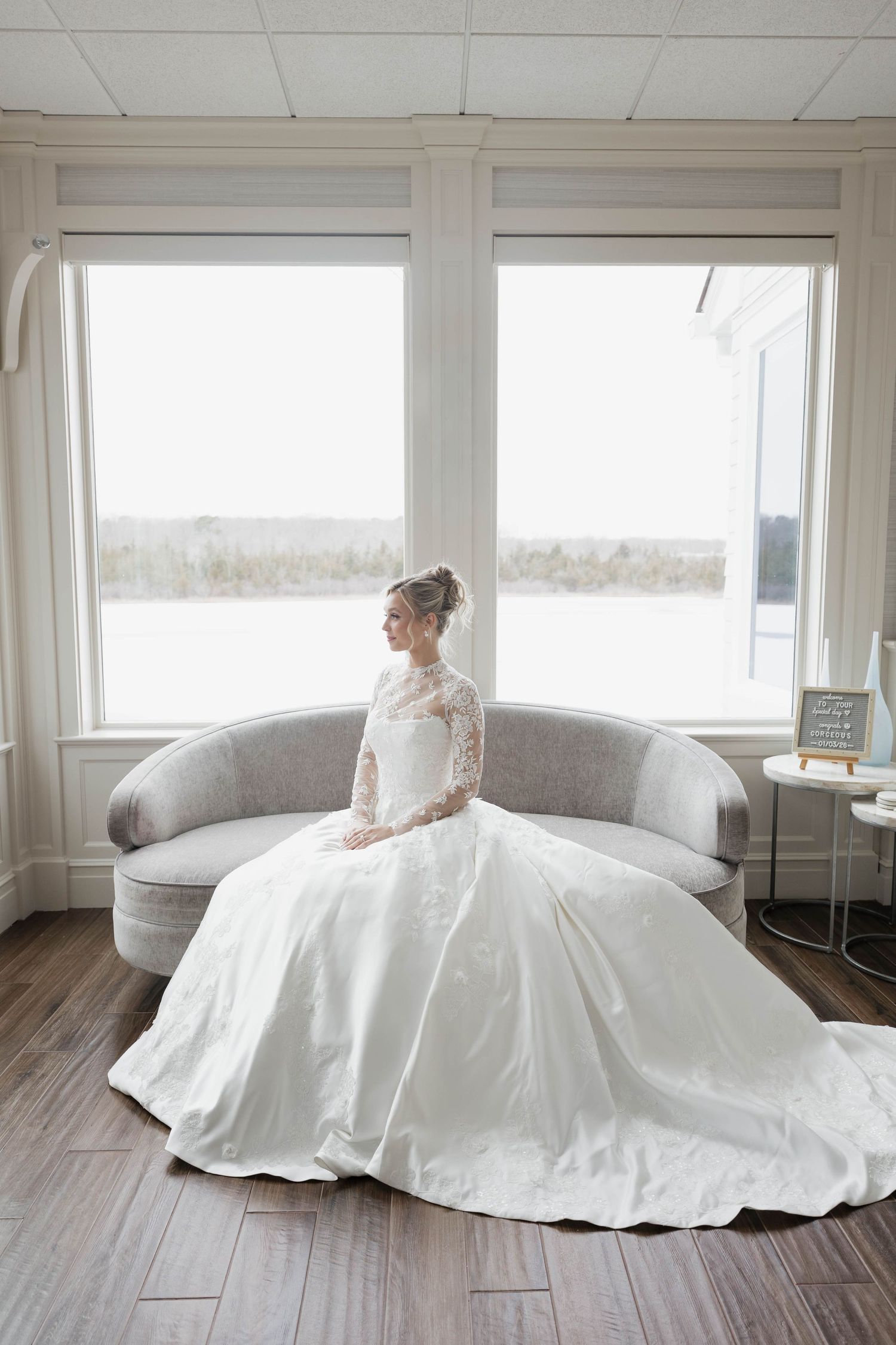 Stunning ballgown wedding dress with voluminous skirt photographed in bright interior setting.