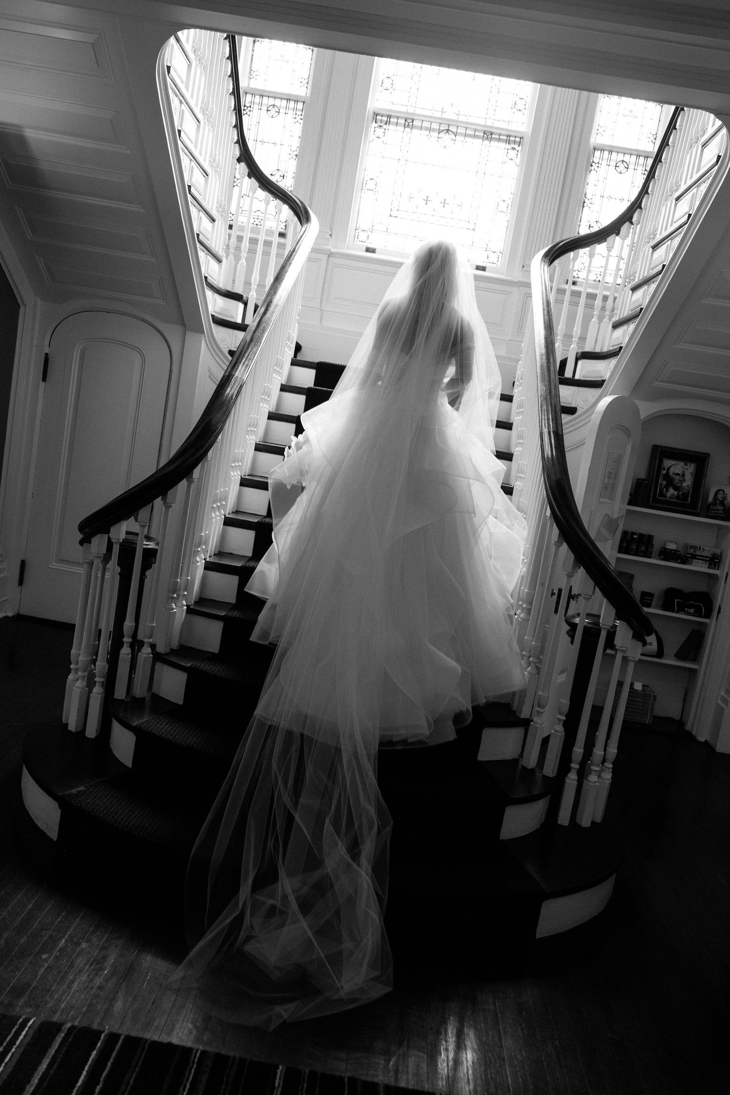 Dramatic black and white photos of wedding dress silhouette against curved staircase and window.