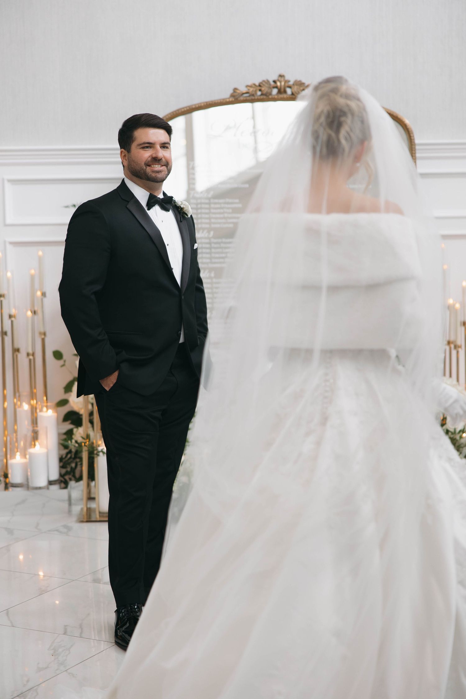 First look moment between bride and groom in an elegant white venue.