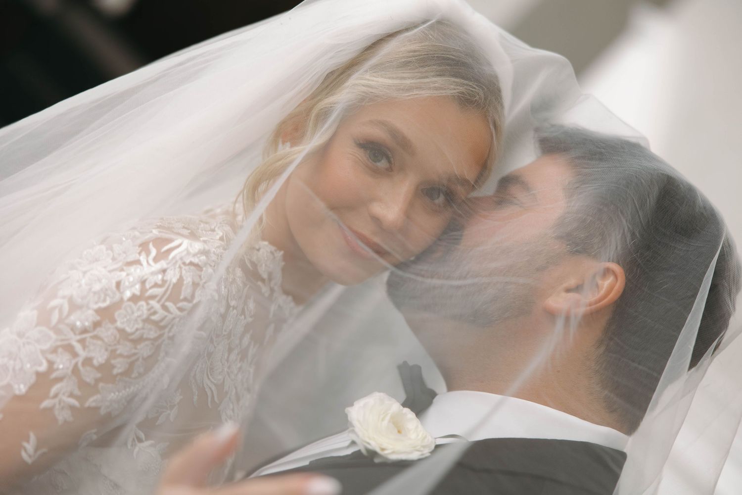 Romantic soft-focus portraits of newlyweds sharing tender moments under veil.
