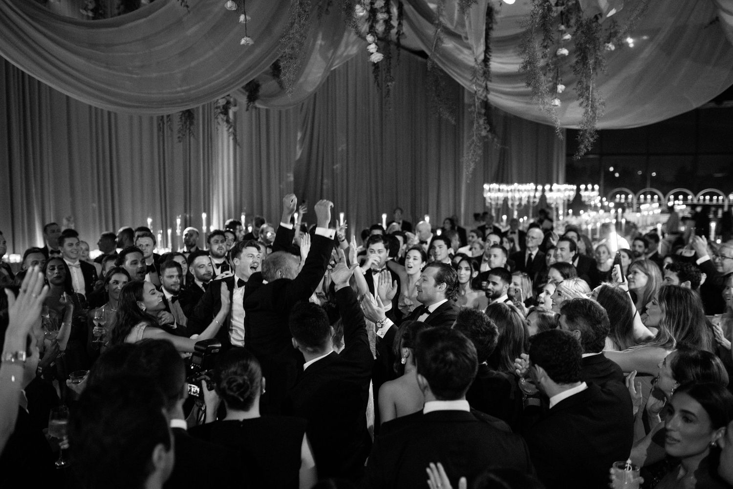 Black and white photos of a wedding reception showing guests dancing and celebrating.