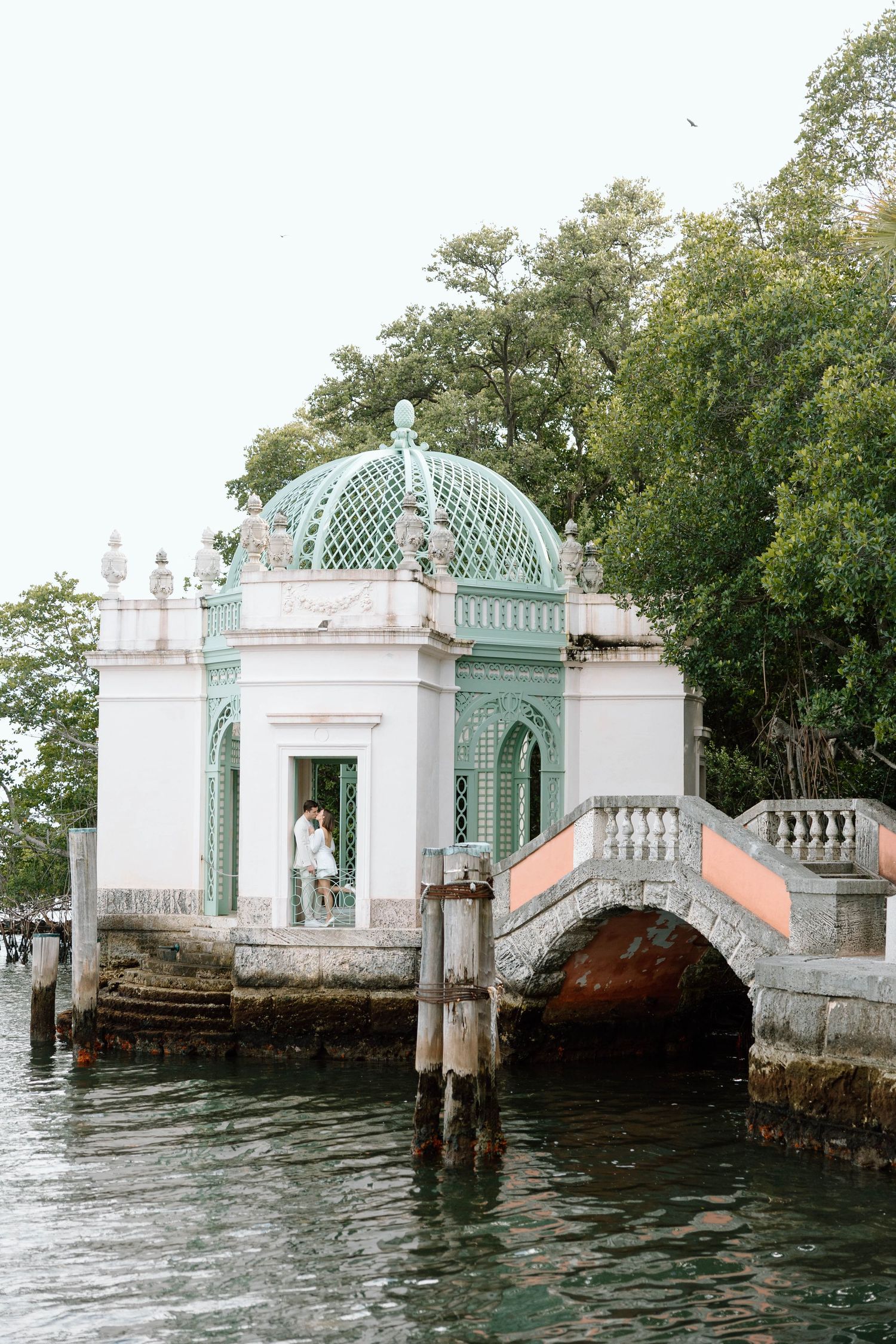 Historic white and mint green boat docks extend into calm waters.
