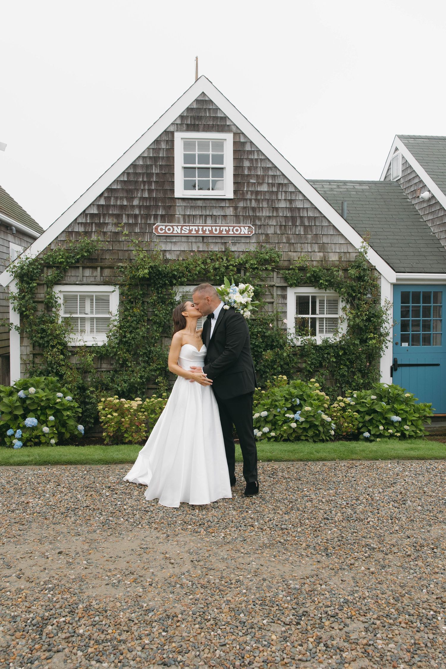 Wedding couple shares romantic moments against backdrop of New England style cottages and gardens.