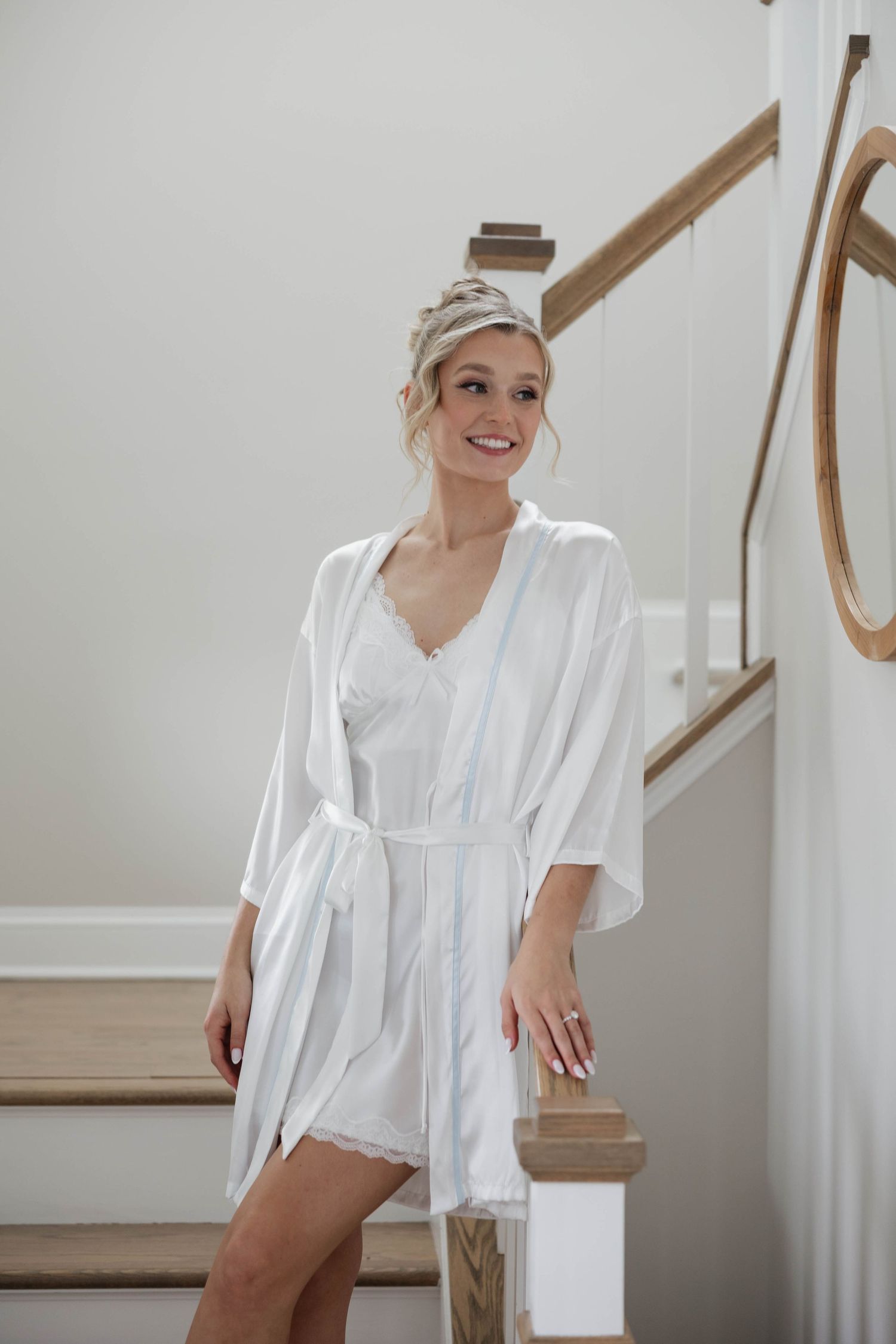 Elegant white bridal robe worn while getting ready on wedding day stairs.