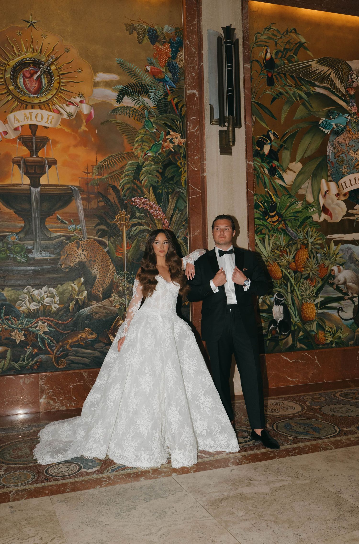 Wedding photos captured against tropical mural backdrop in an elegant indoor setting.
