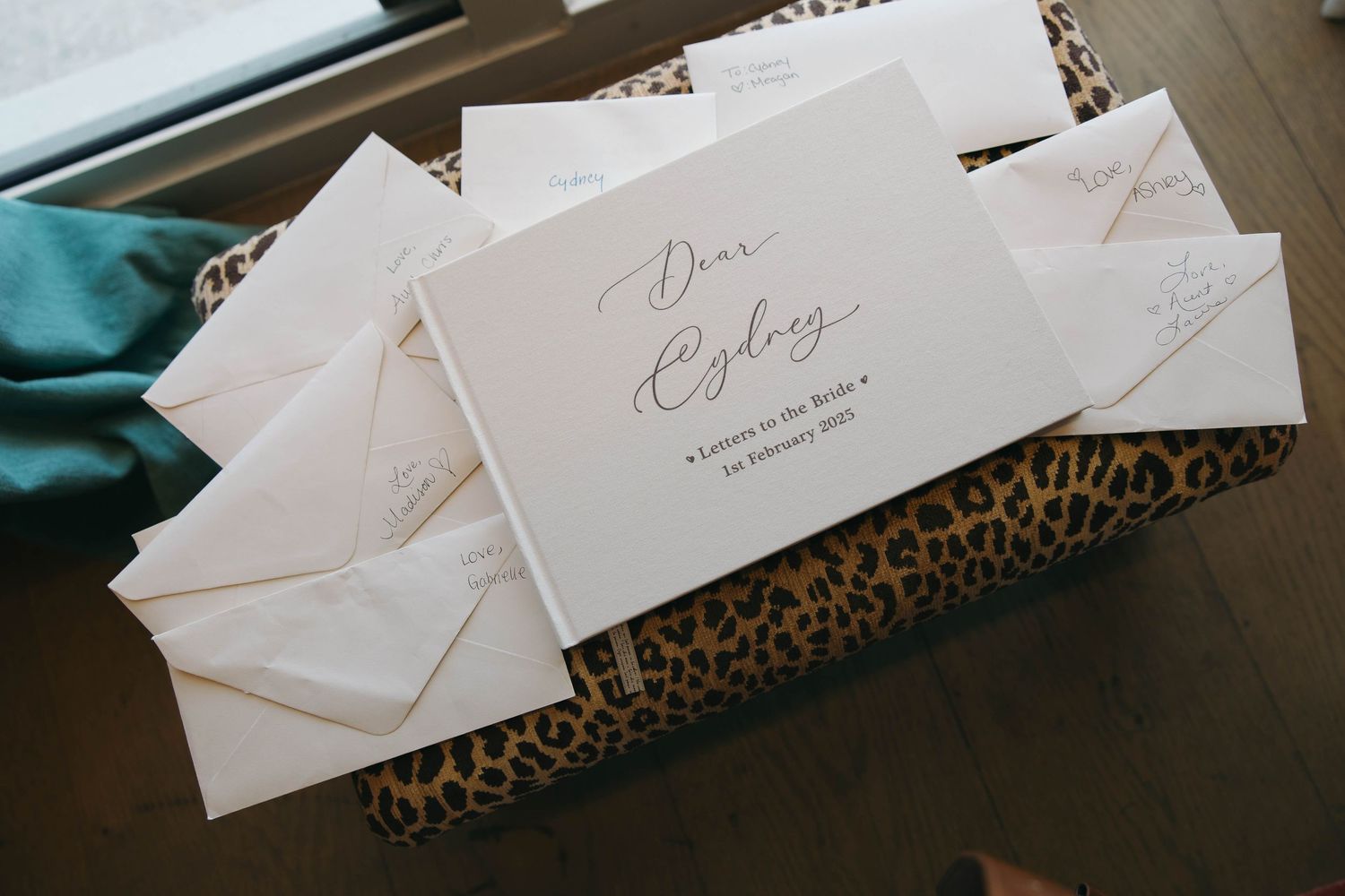 White envelopes and cards arranged on a leopard print surface in dim lighting.