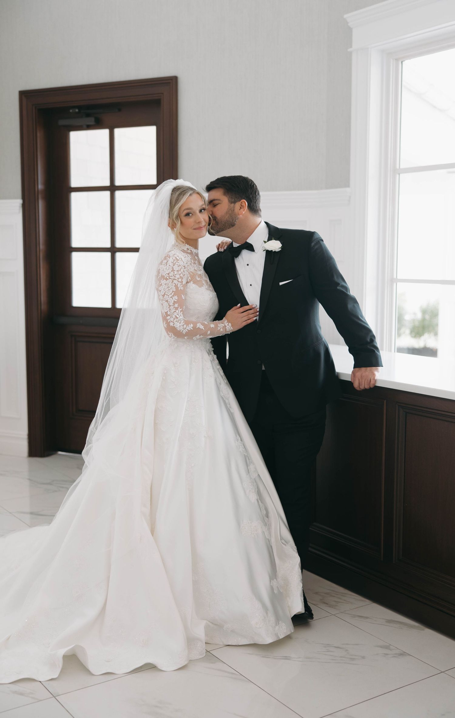 Romantic wedding portraits in an elegant room with dark wood accents.