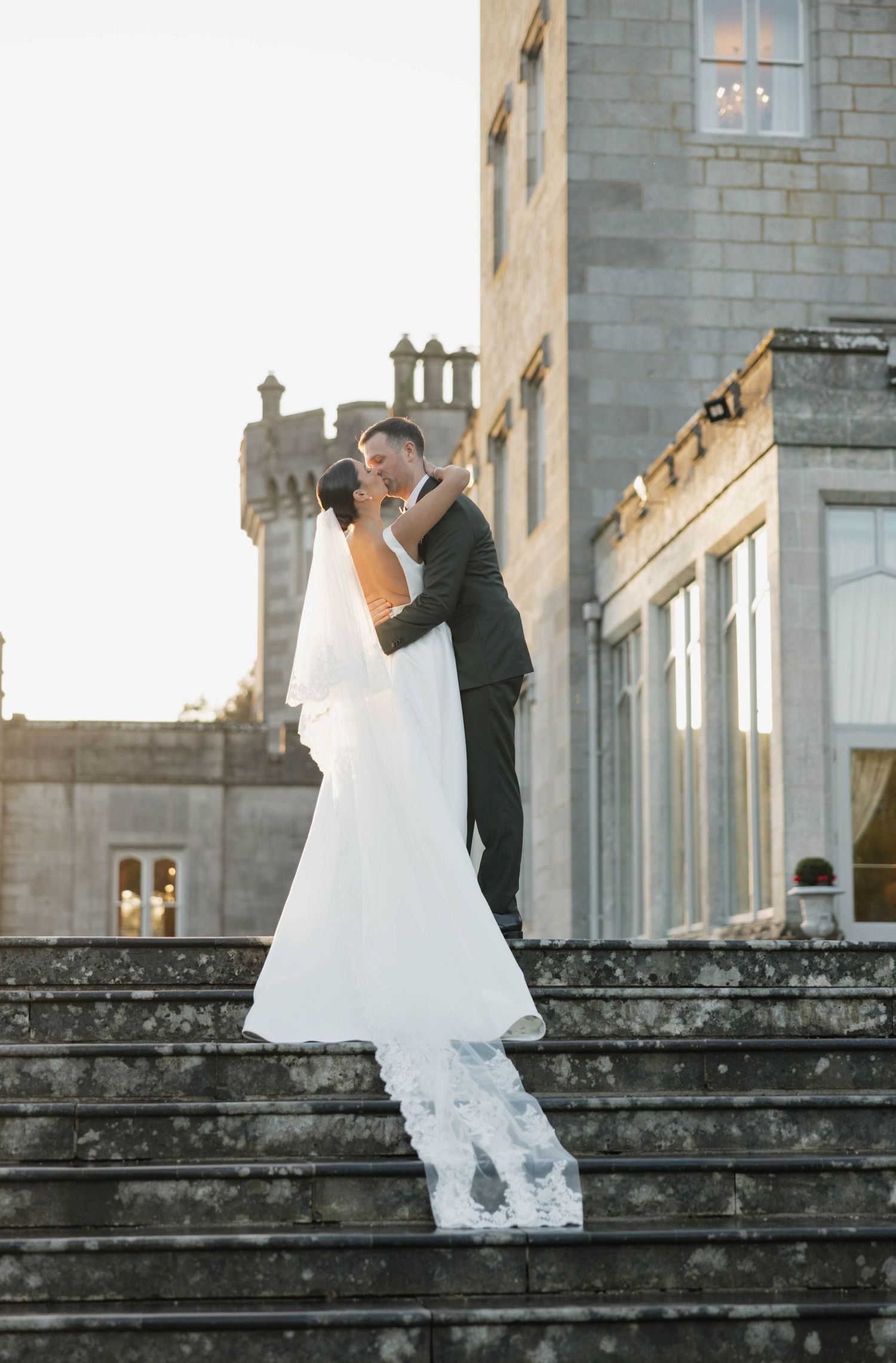 Couple shares romantic moment on historic stone steps during wedding.