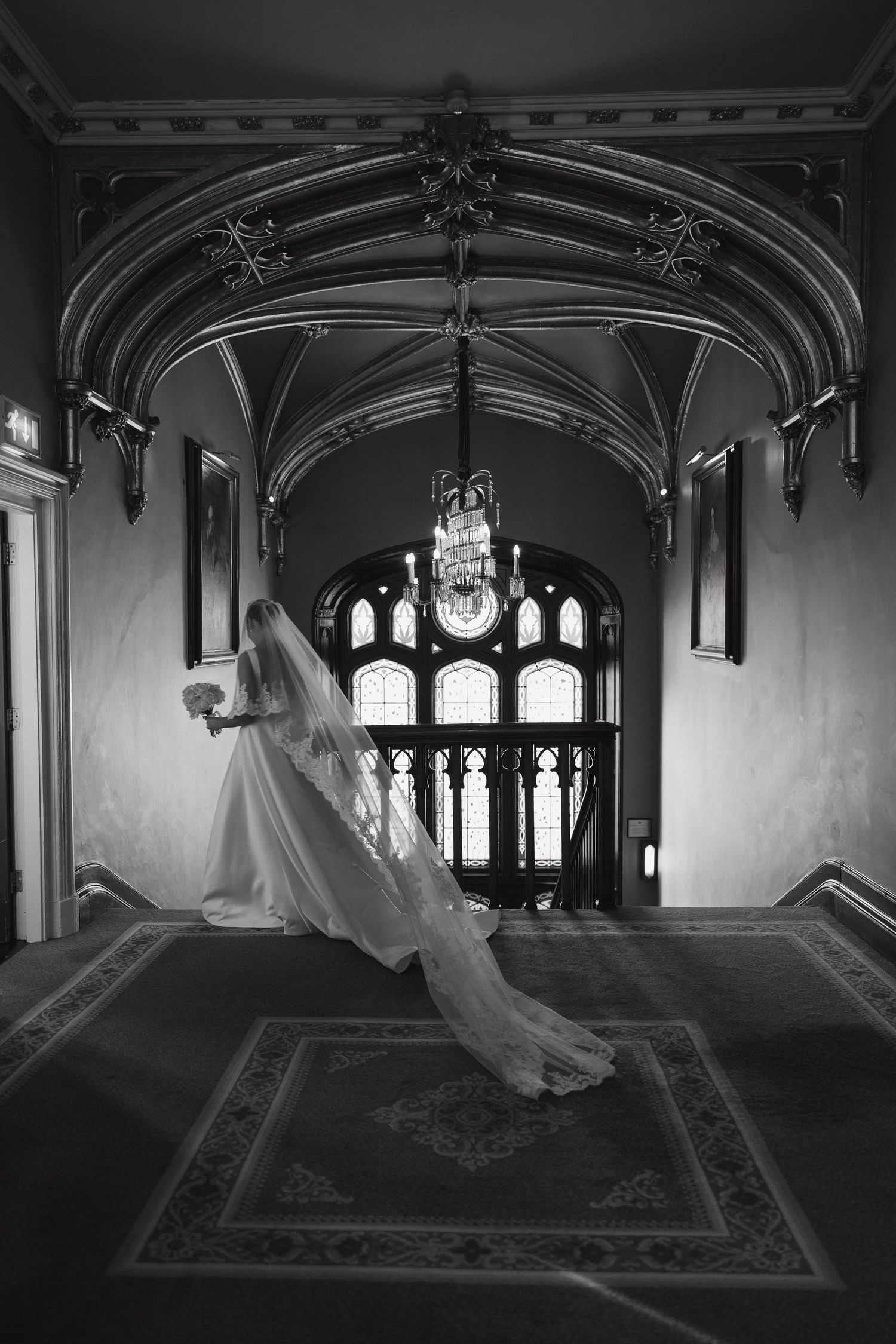 Artistic black and white sequence in a Gothic-style room with vaulted ceilings and ornate windows.