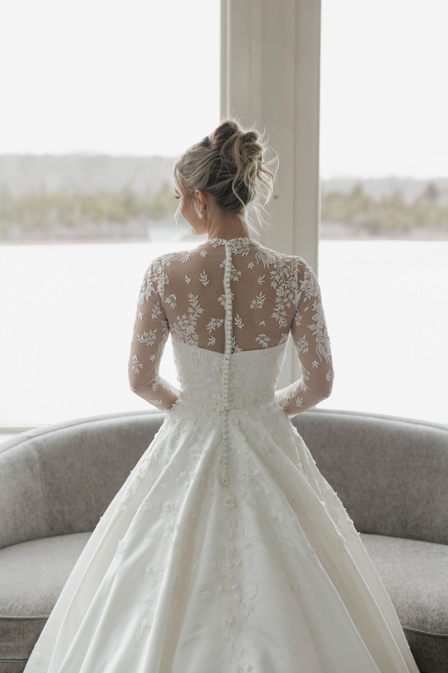 Back view of wedding dress showing sheer lace detail and buttons.