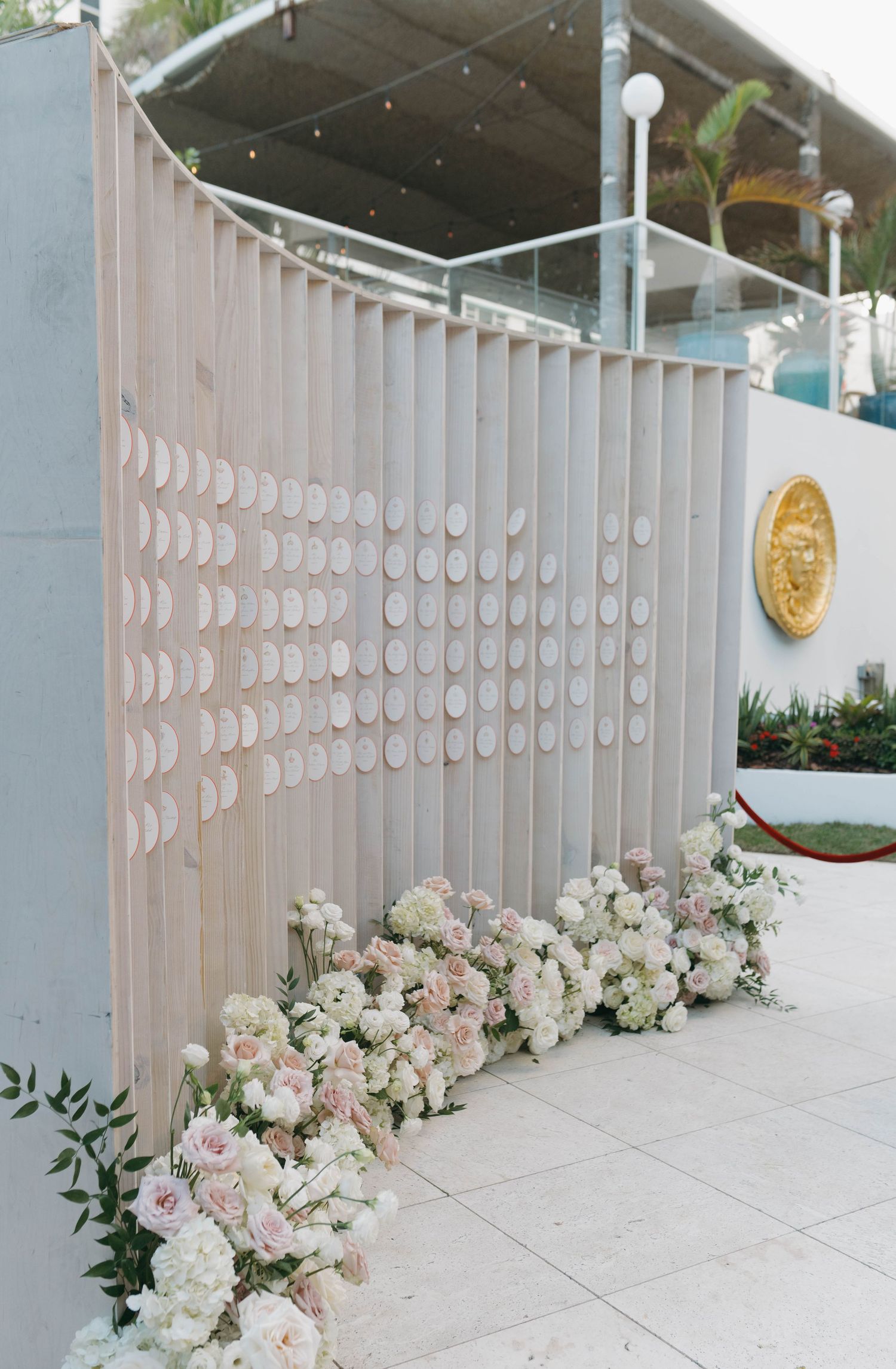 Moon phase wall decoration with white and pink floral arrangements along the base.