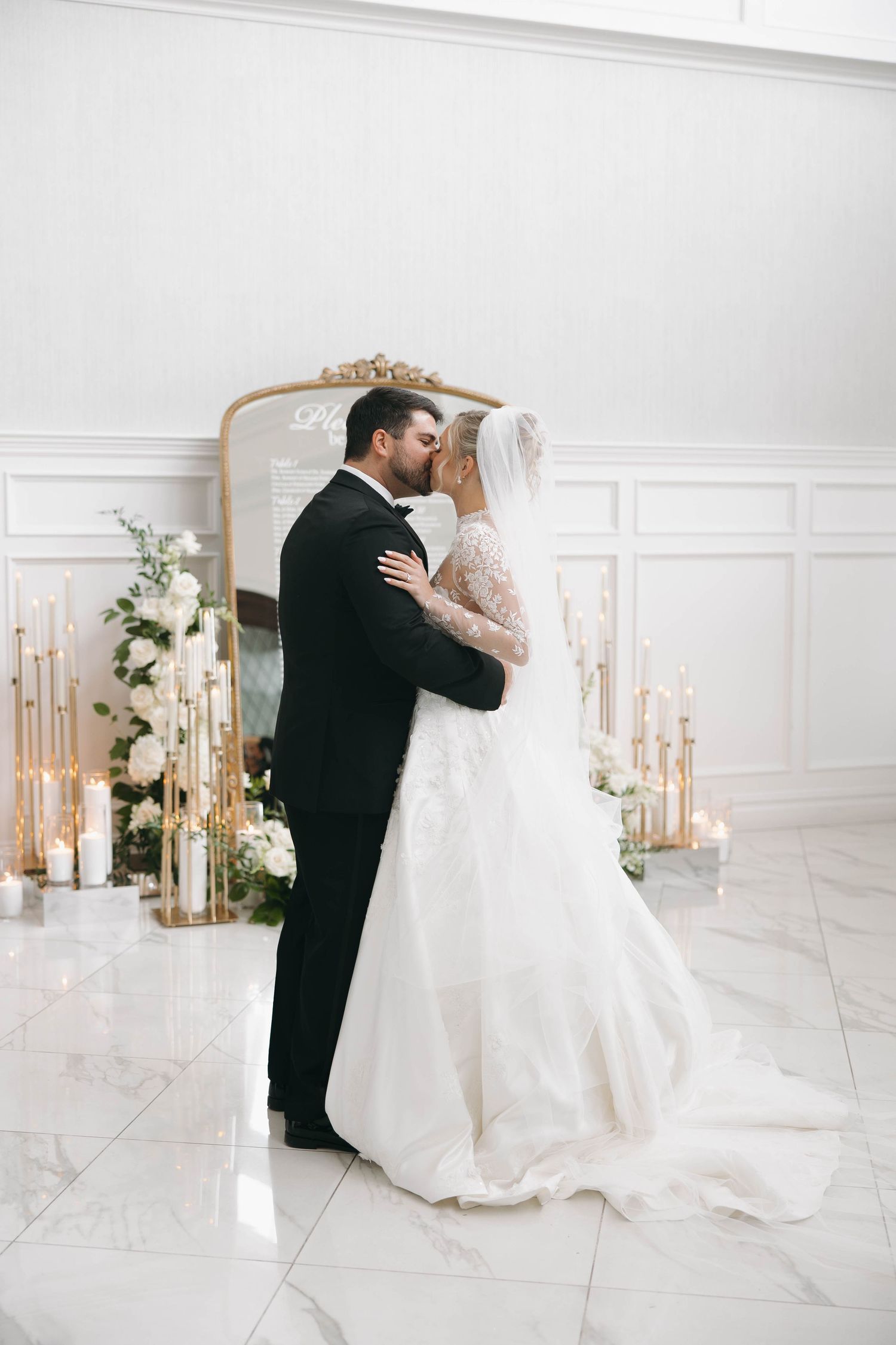 A romantic first dance sequence between newlyweds in an elegant white ballroom with floral decor.