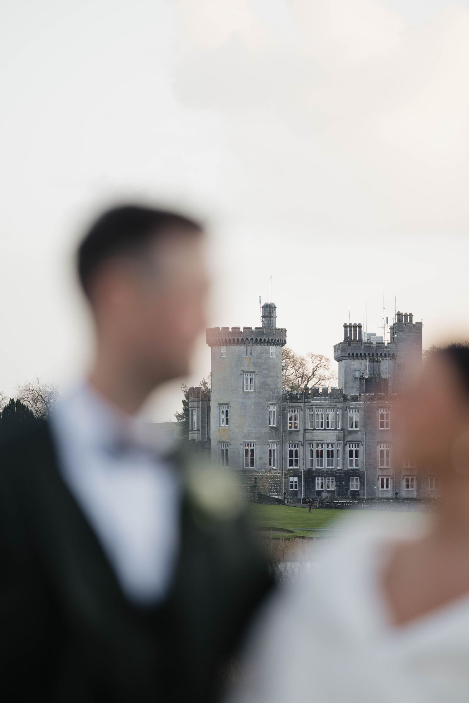 A castle with turrets provides an elegant backdrop for wedding photos.
