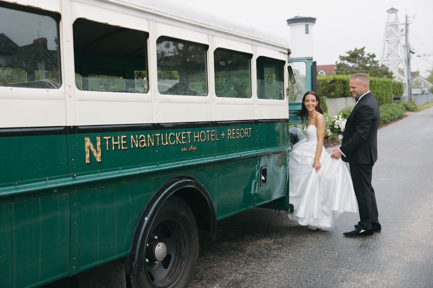 Wedding couple stands beside classic green Nantucket Hotel shuttle bus.
