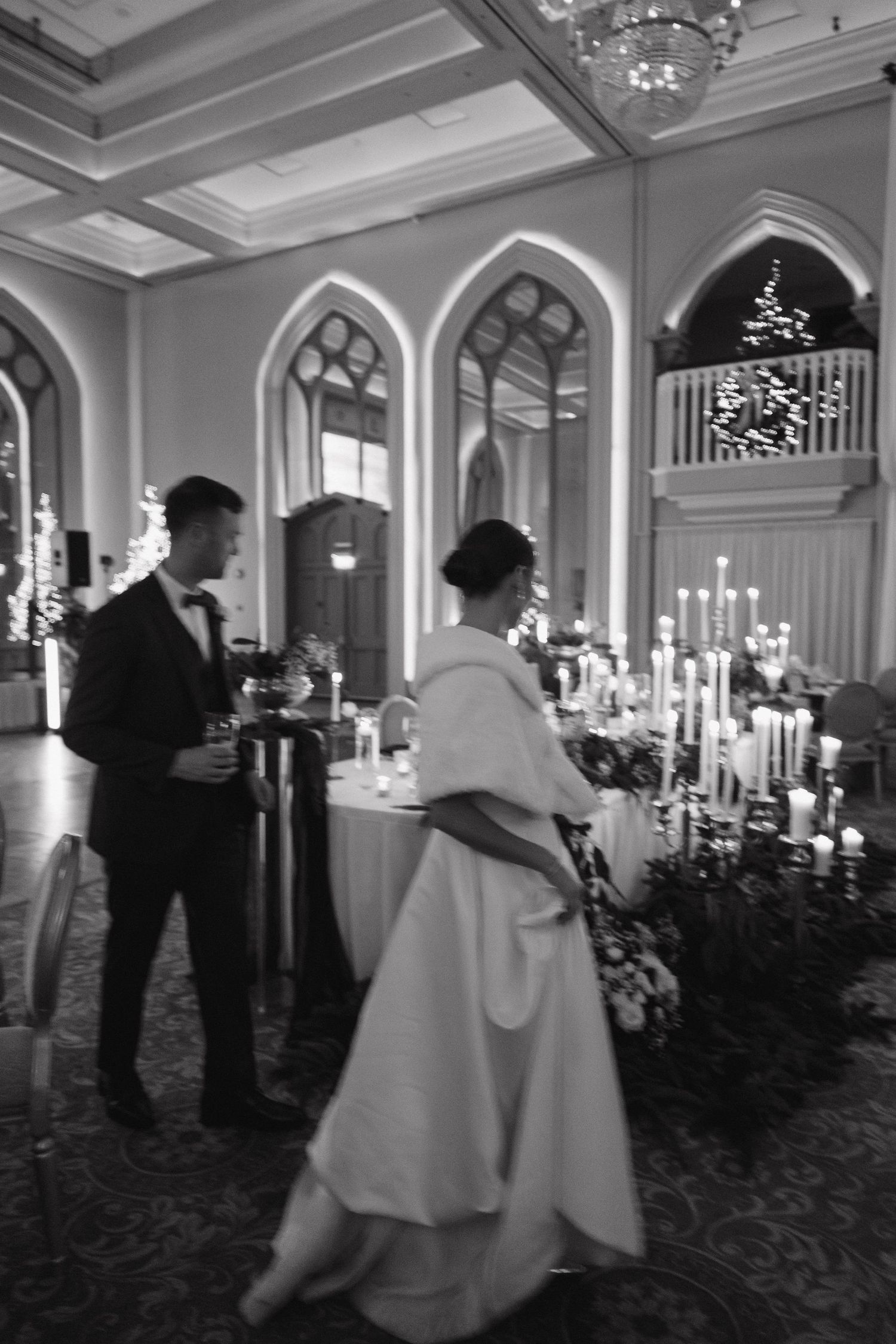 A black and white photo series showing dancing figures in an elegant ballroom with arched windows.