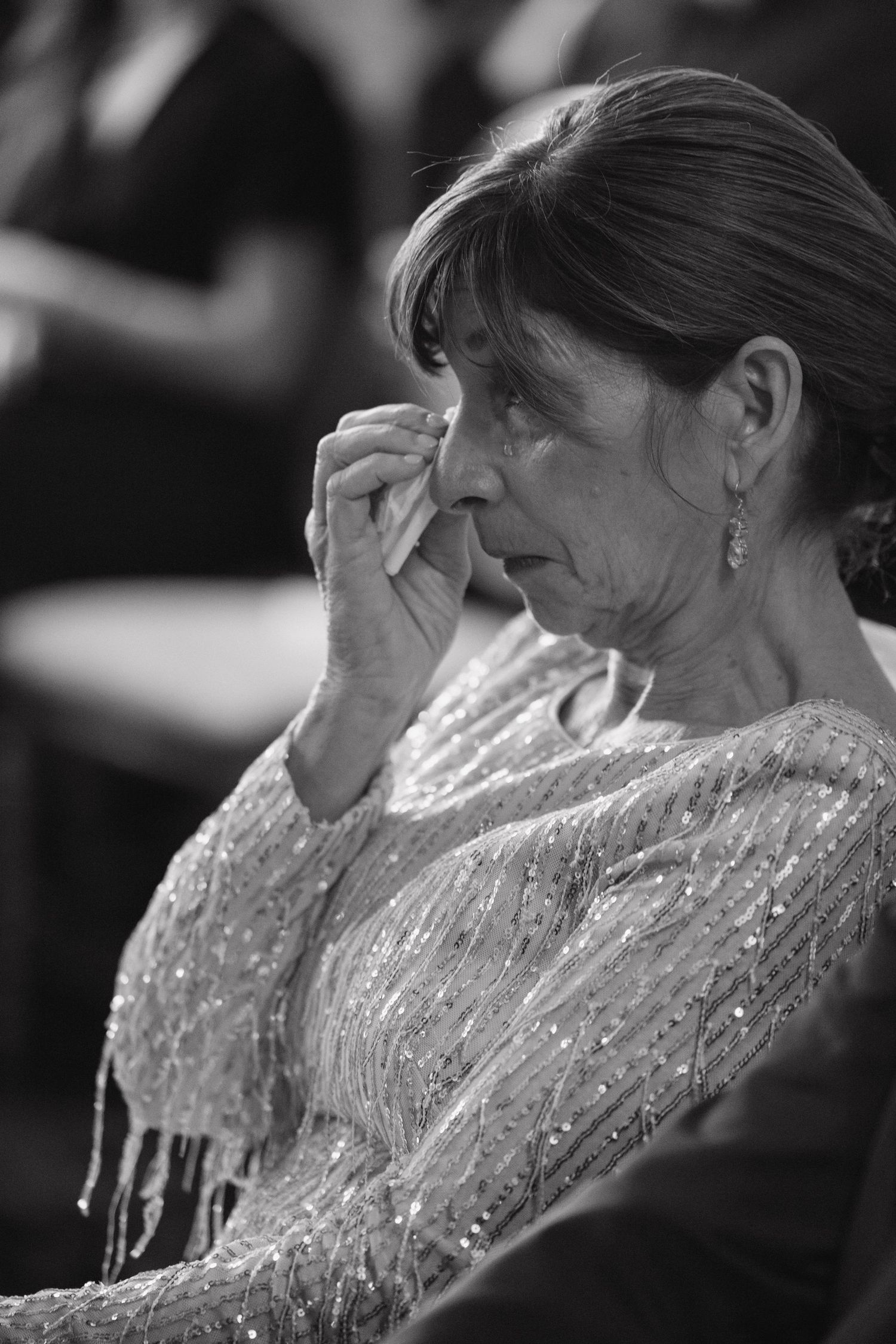 A sequence of emotional black and white photos showing a person in a sparkly dress wiping tears.