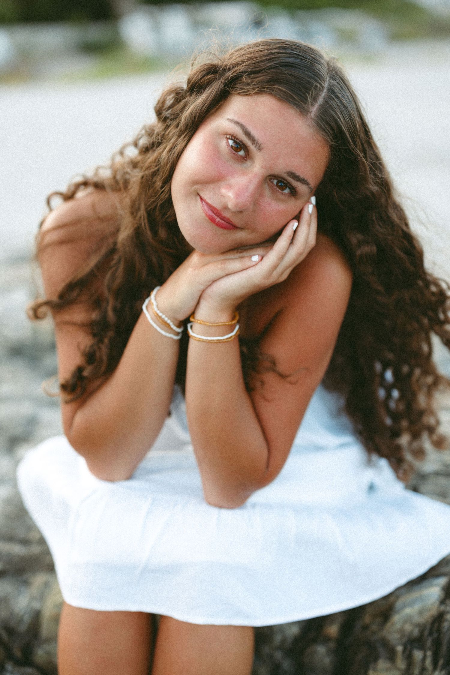 Artistic portrait series with white top against waterfront background.