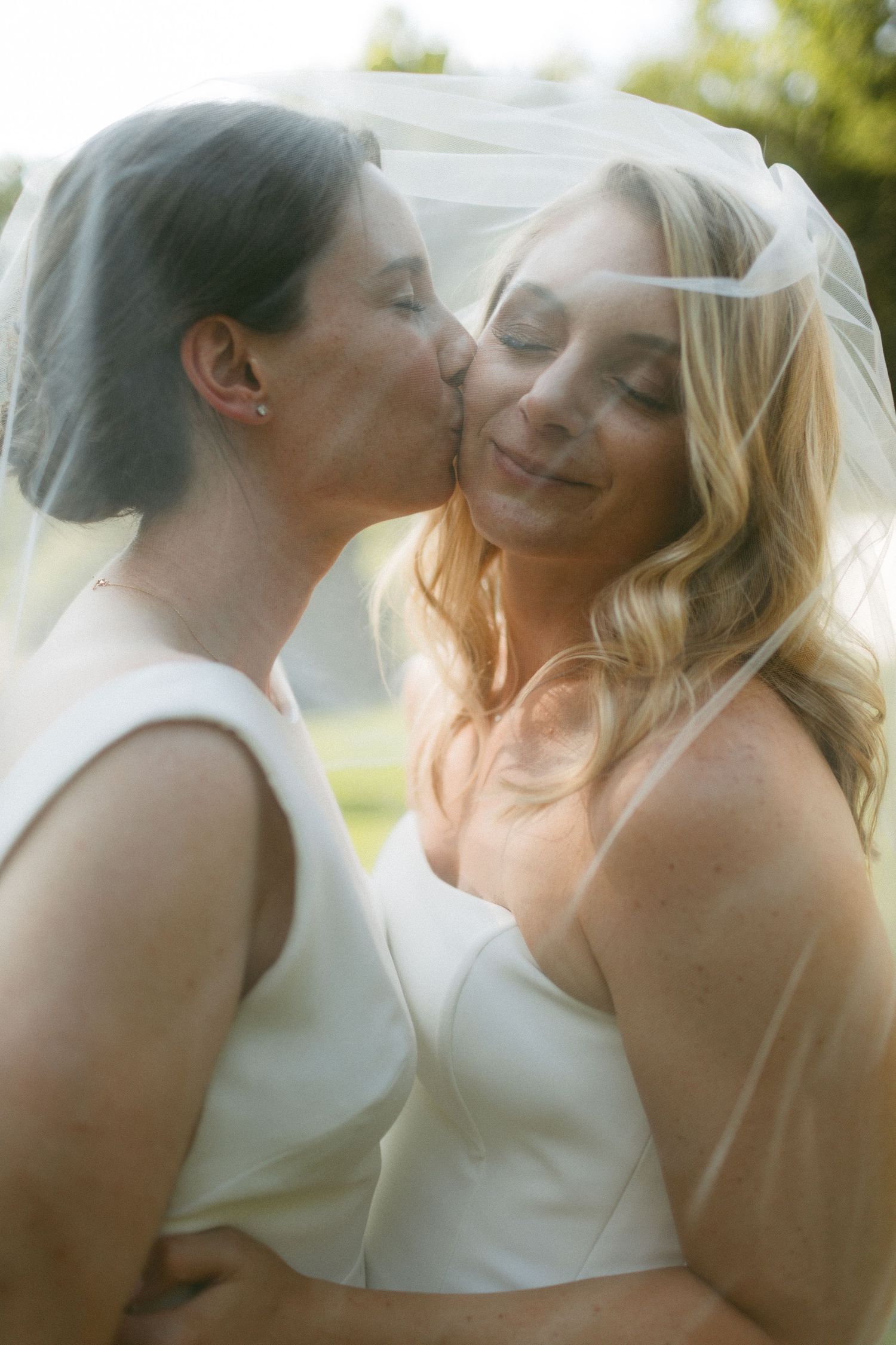 Soft, romantic wedding photos showing tender moments through a veil in natural light.