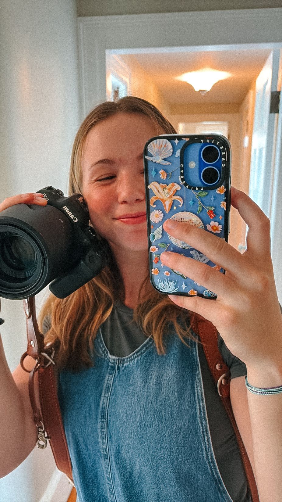 Series of mirror selfies showing a person in denim holding a camera with a decorative phone case.