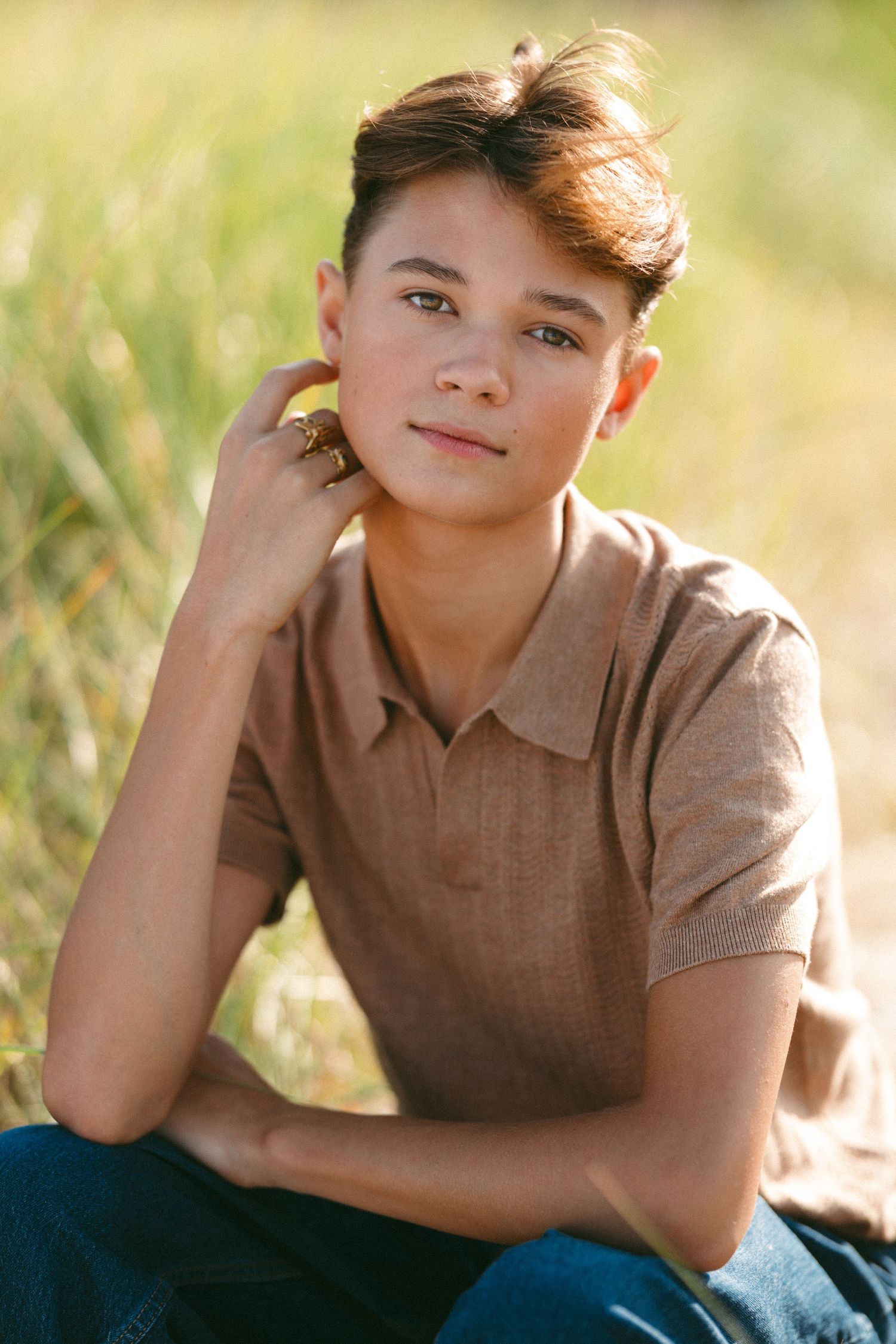 Portrait series showing person in brown polo shirt laying in grass.