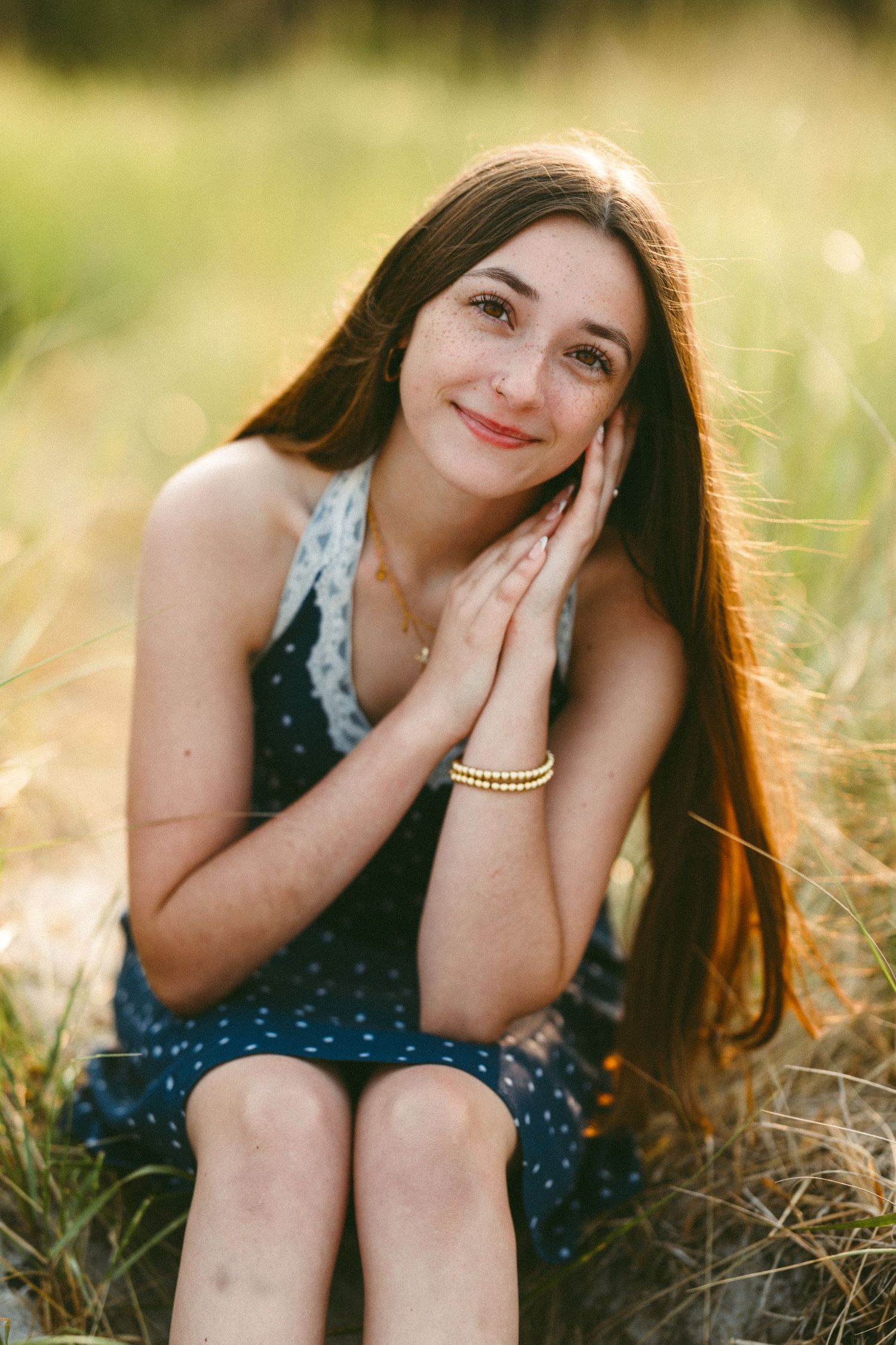Sunset portrait series showing person in polka dot dress laying in golden field.