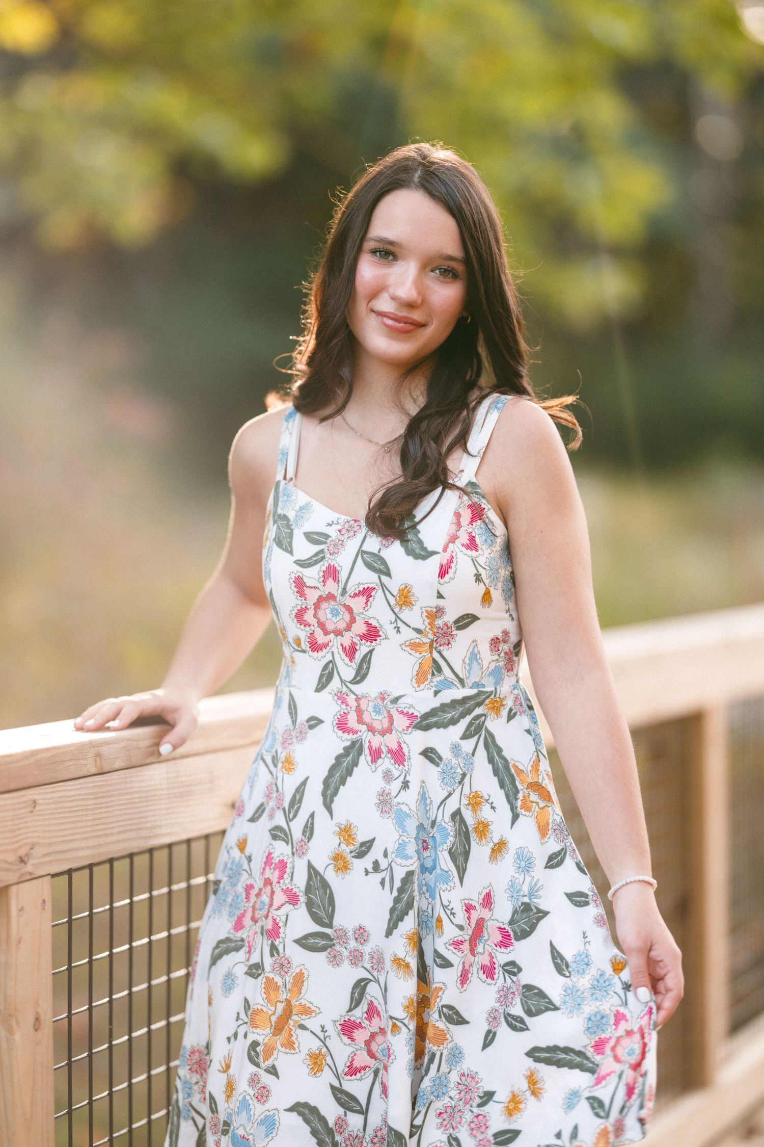 A floral summer dress brightens up a wooden bridge walkway during golden hour.