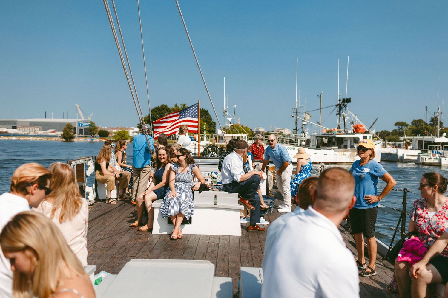Wedding guests gathered at a sunny marina dock for a waterfront celebration.
