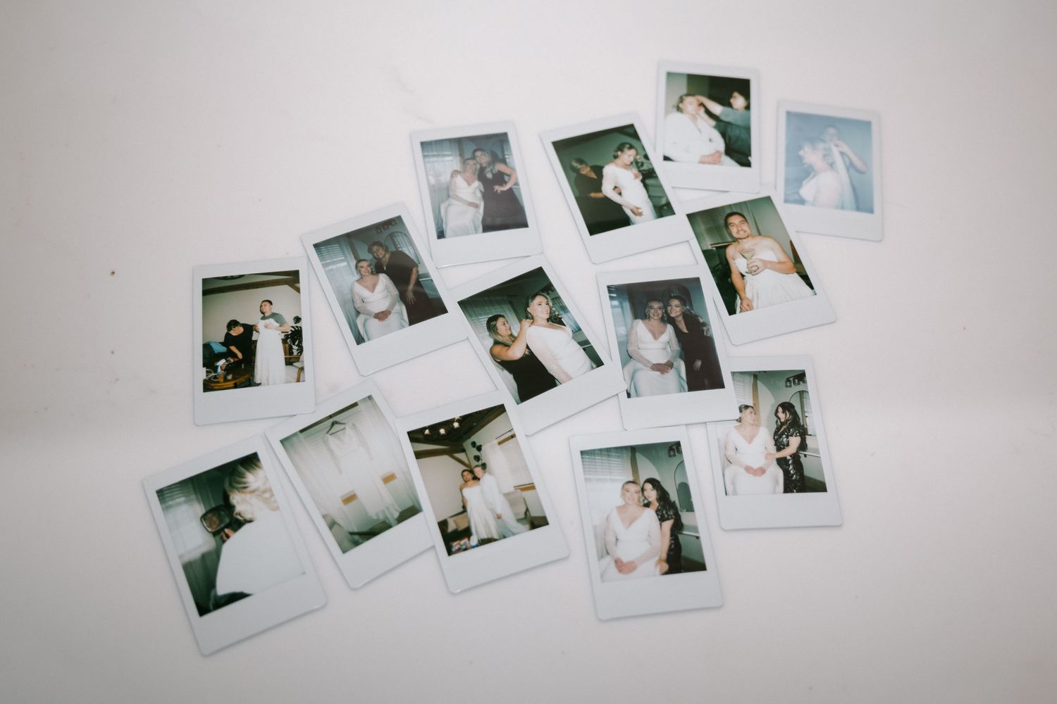 A collection of instant polaroid photographs arranged in a scattered layout on a white surface.