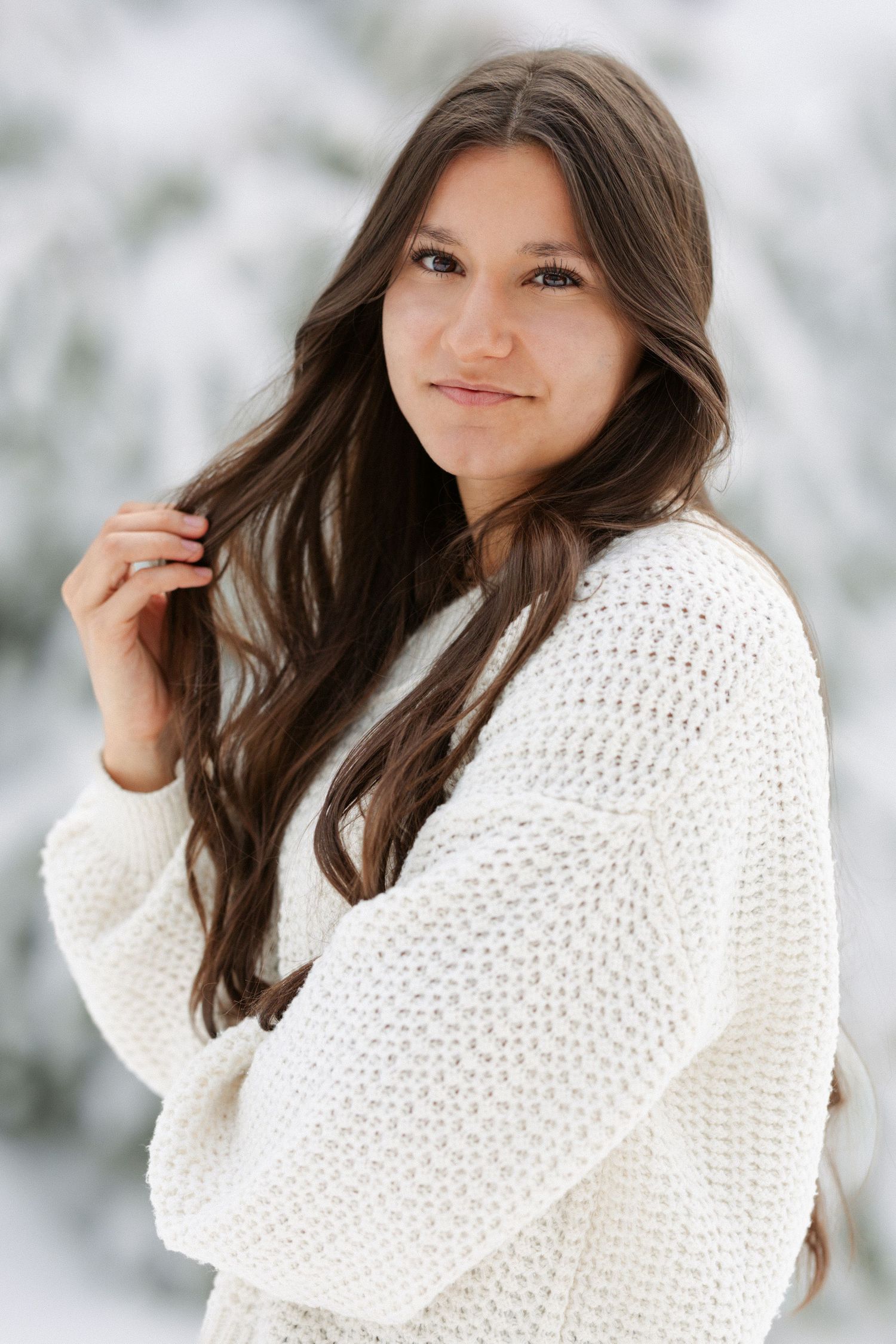 A winter portrait series featuring a cozy white knit sweater against a snowy outdoor background.