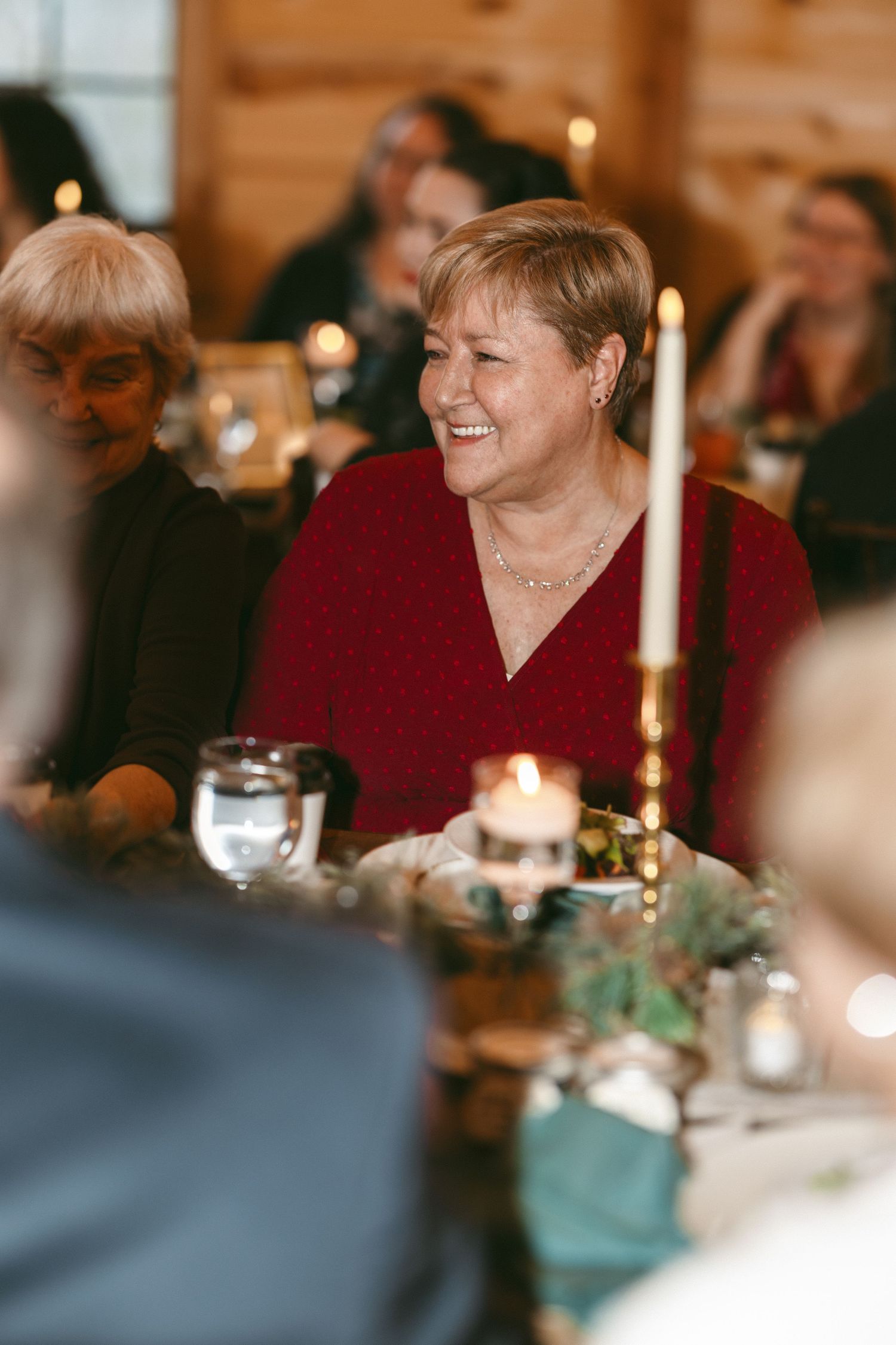 Candlelit dinner scene with warm ambiance showing laughter and conversation across an elegant table setting.