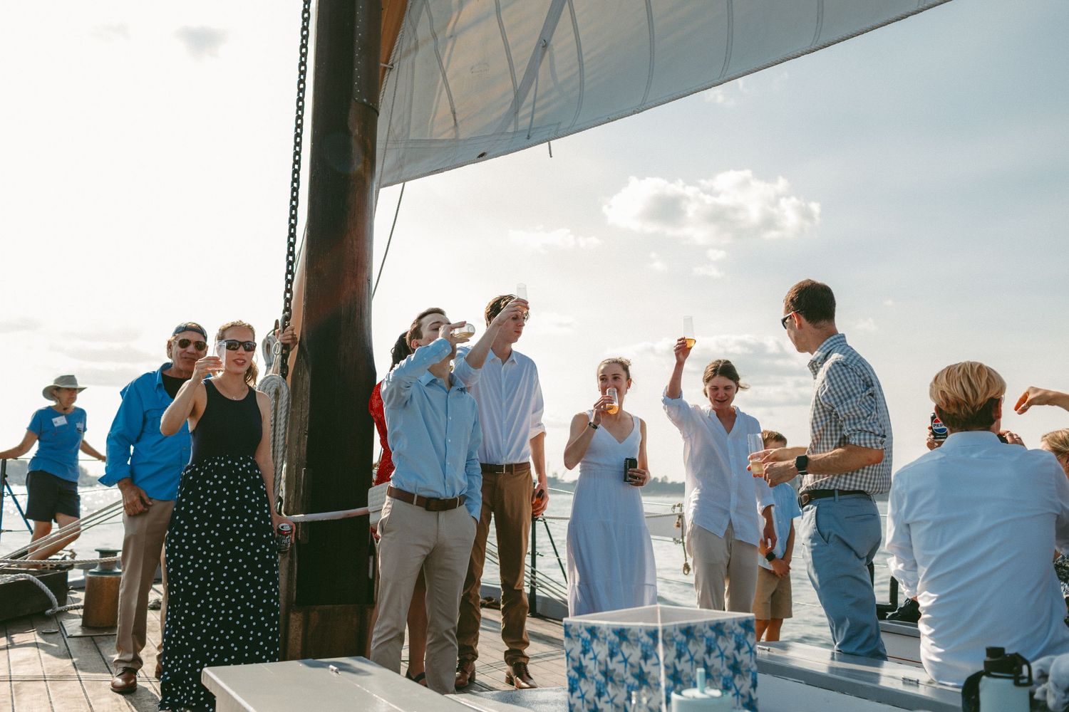 Wedding guests gather on a boat deck during a nautical celebration.