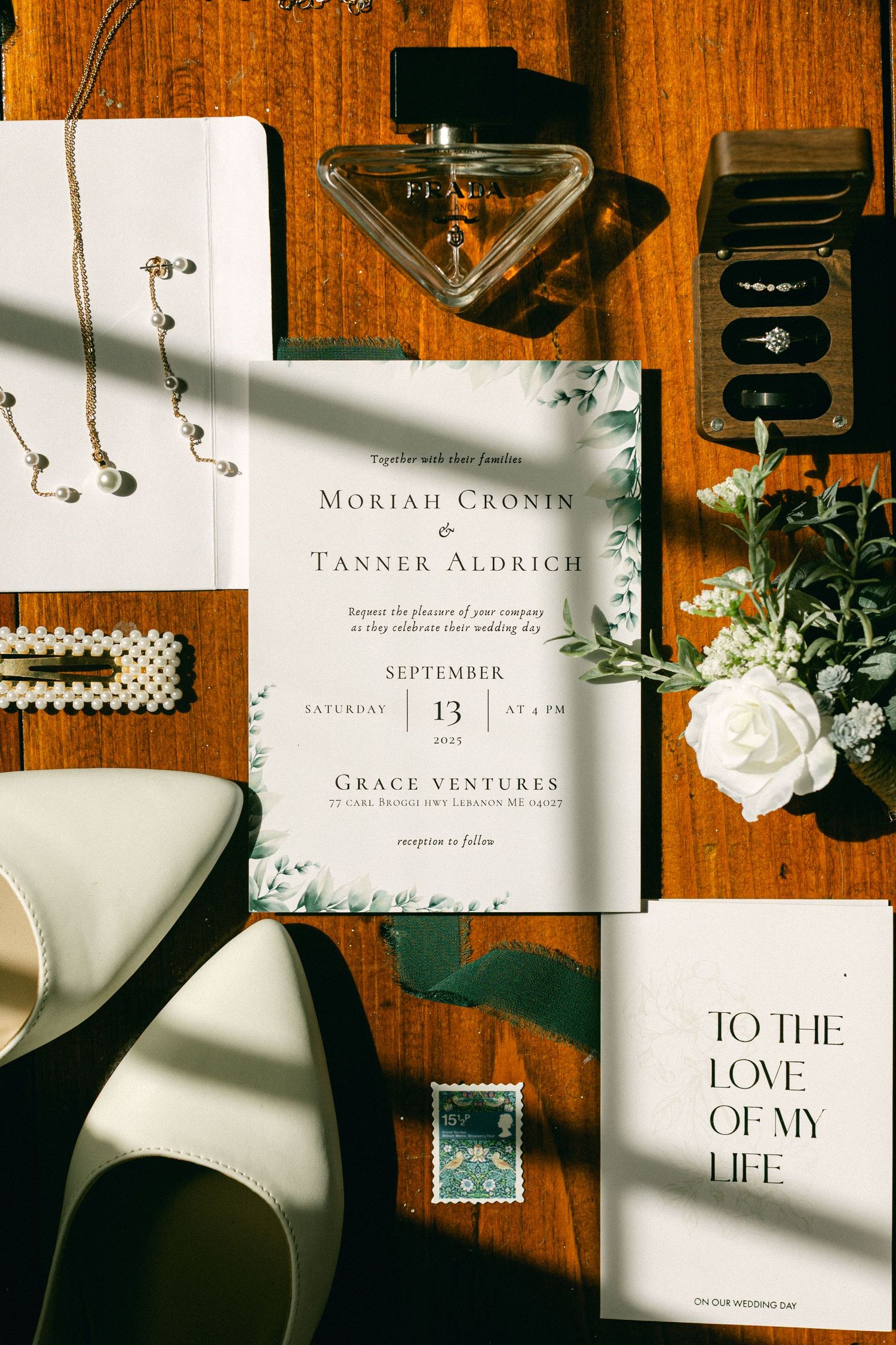 Wedding stationery and invitations arranged artistically on a wooden surface with natural lighting.