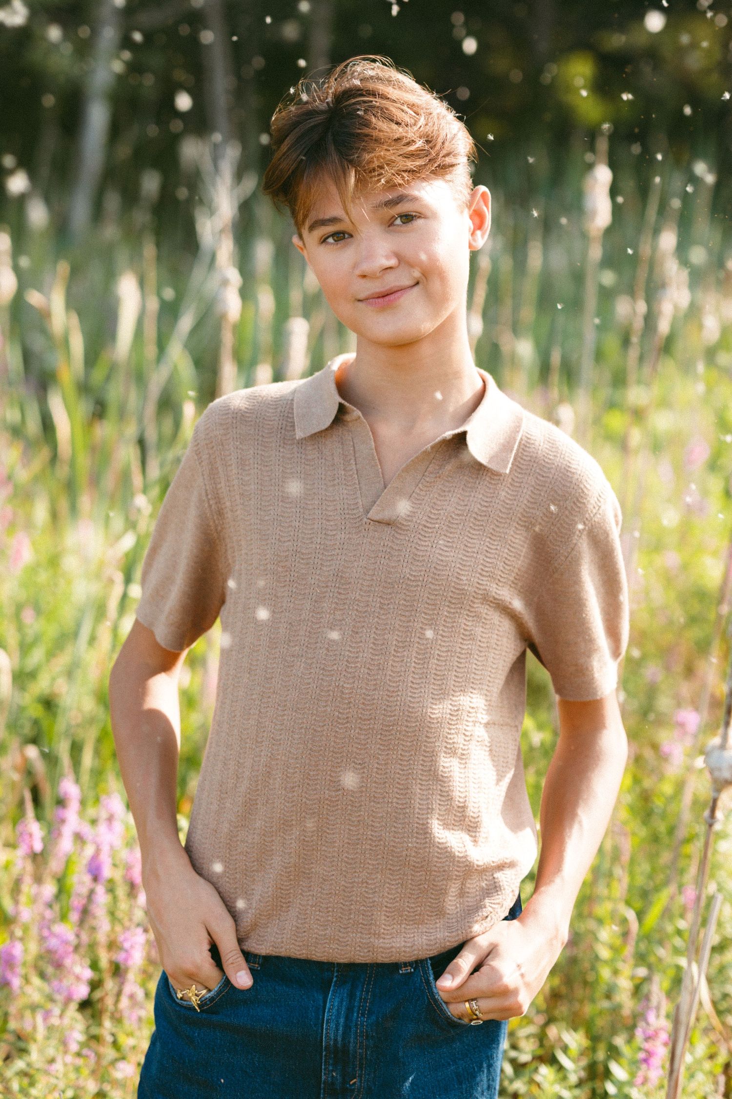 Summer portrait session in a wildflower field with sunlit bokeh effects.