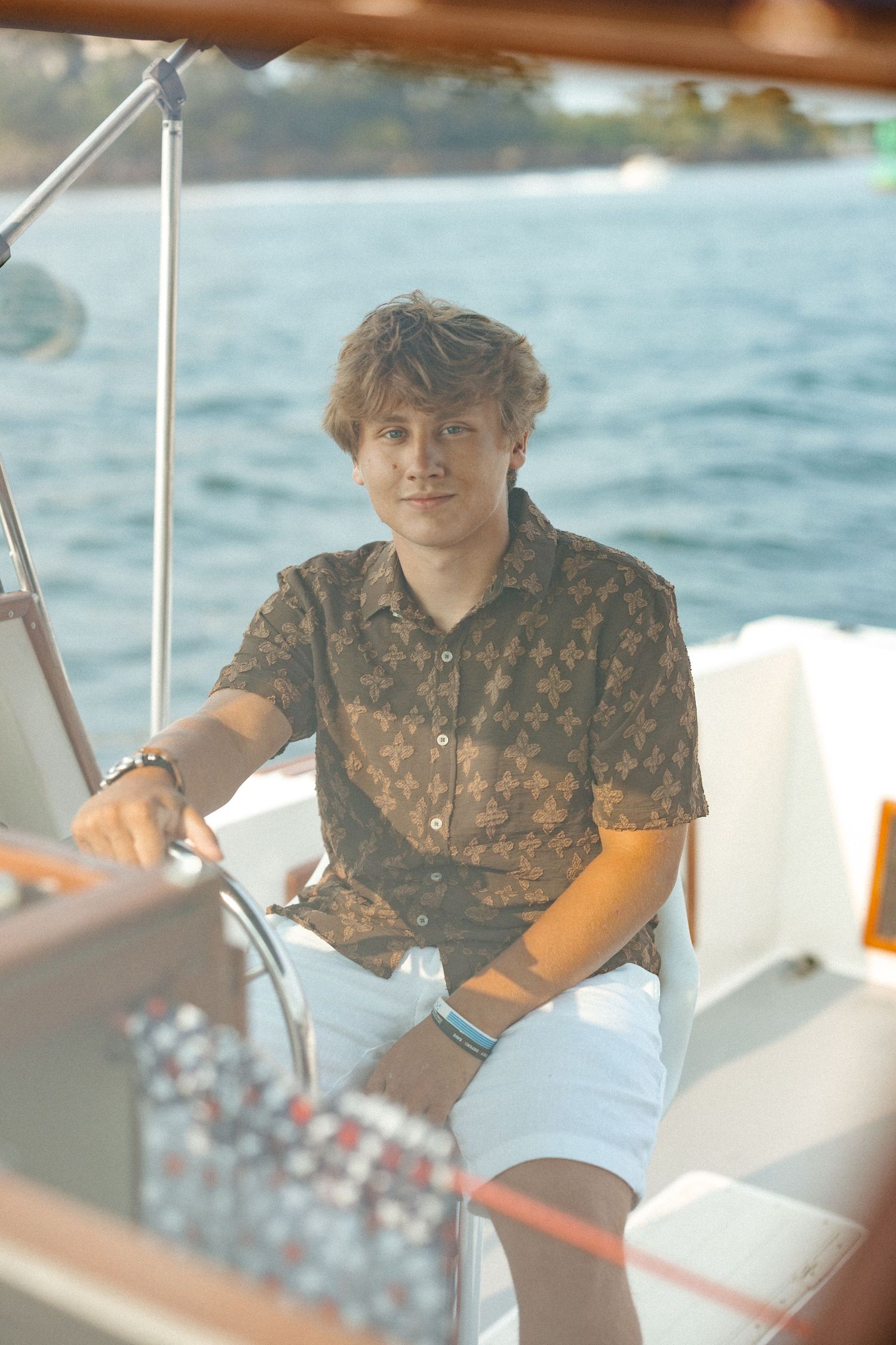 Casual boating scene with someone wearing a patterned shirt on a sunny day.