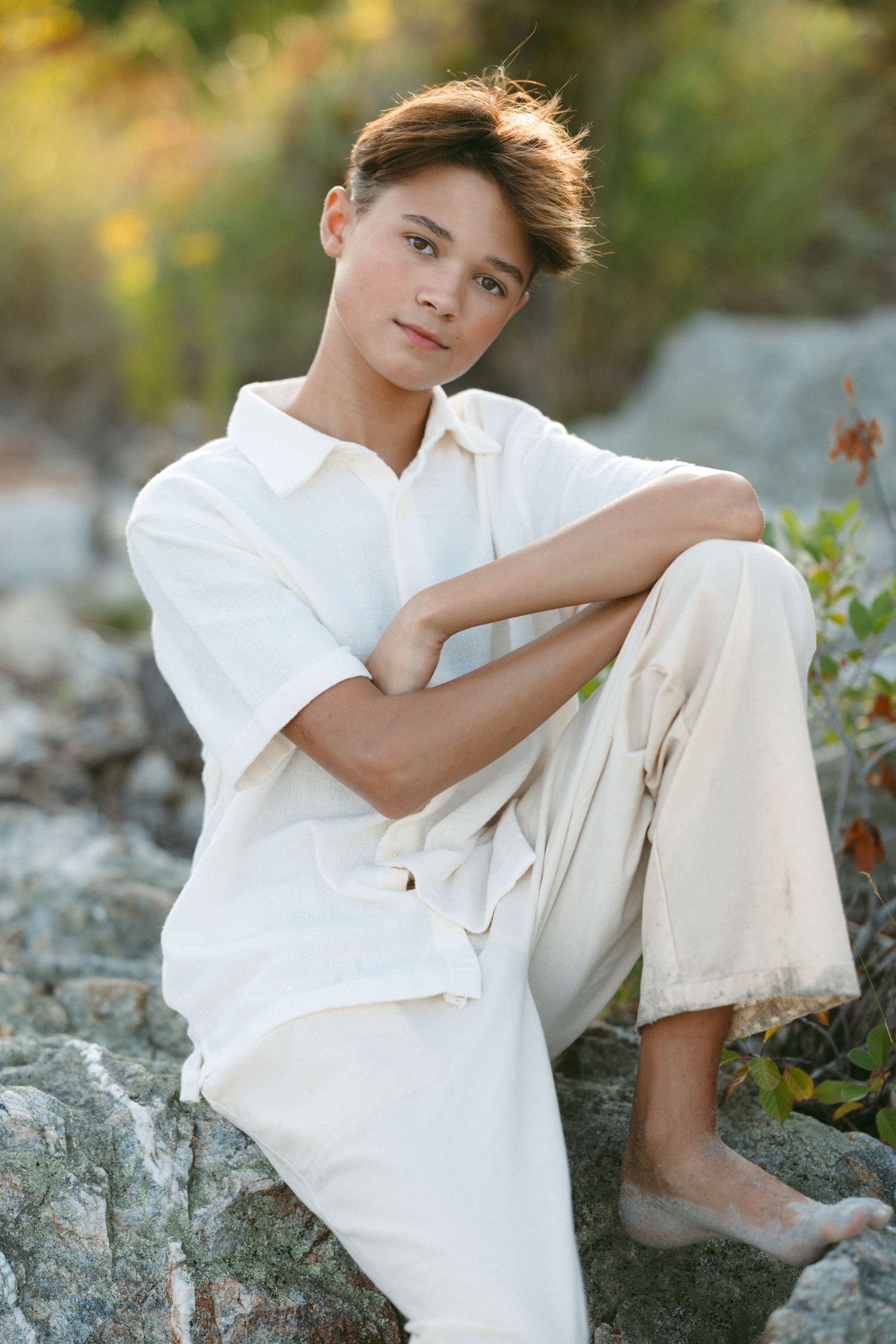 Outdoor portrait session on rocky terrain with white clothing against natural backdrop.