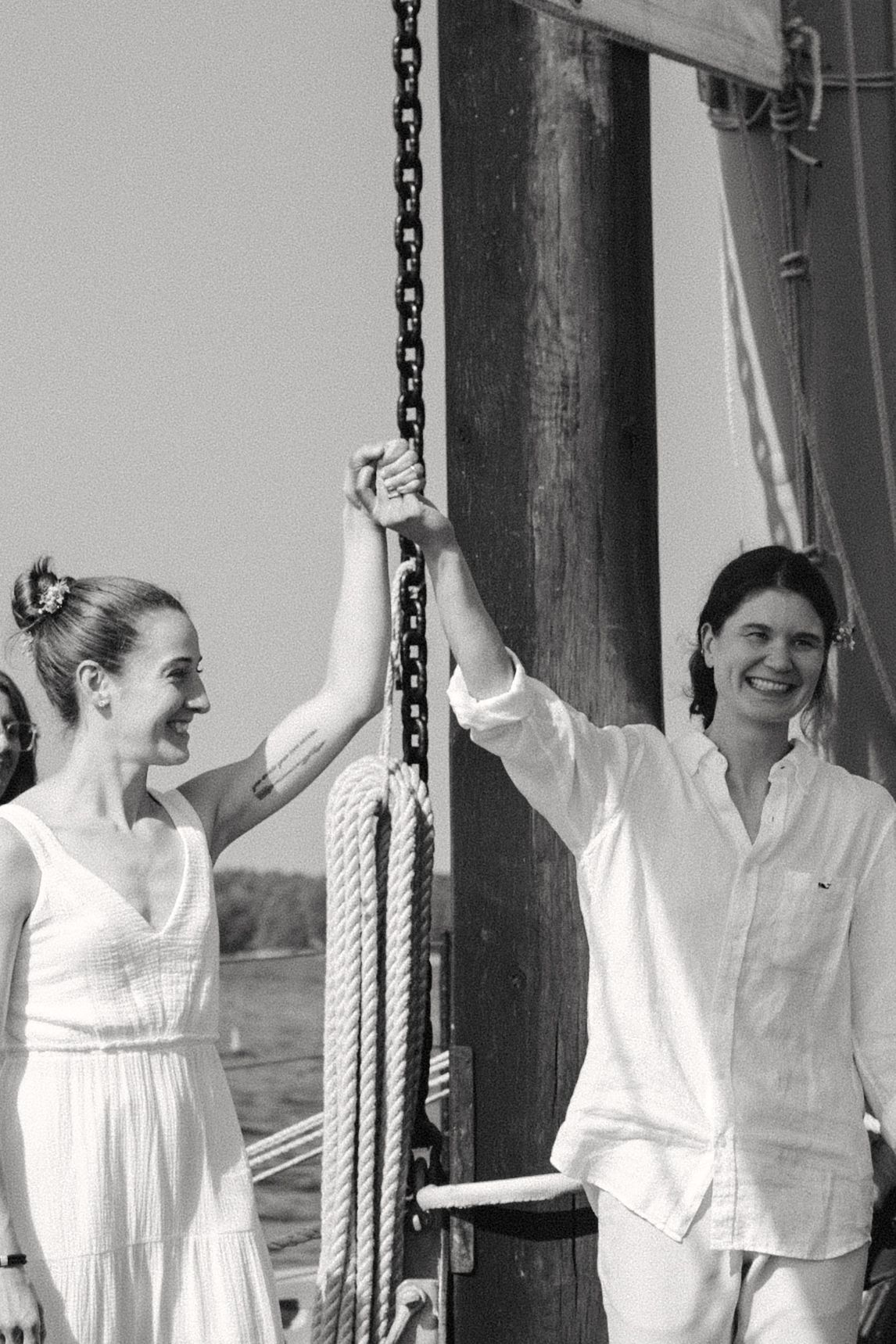 Joyful celebration moment captured in black and white on a sailboat deck.