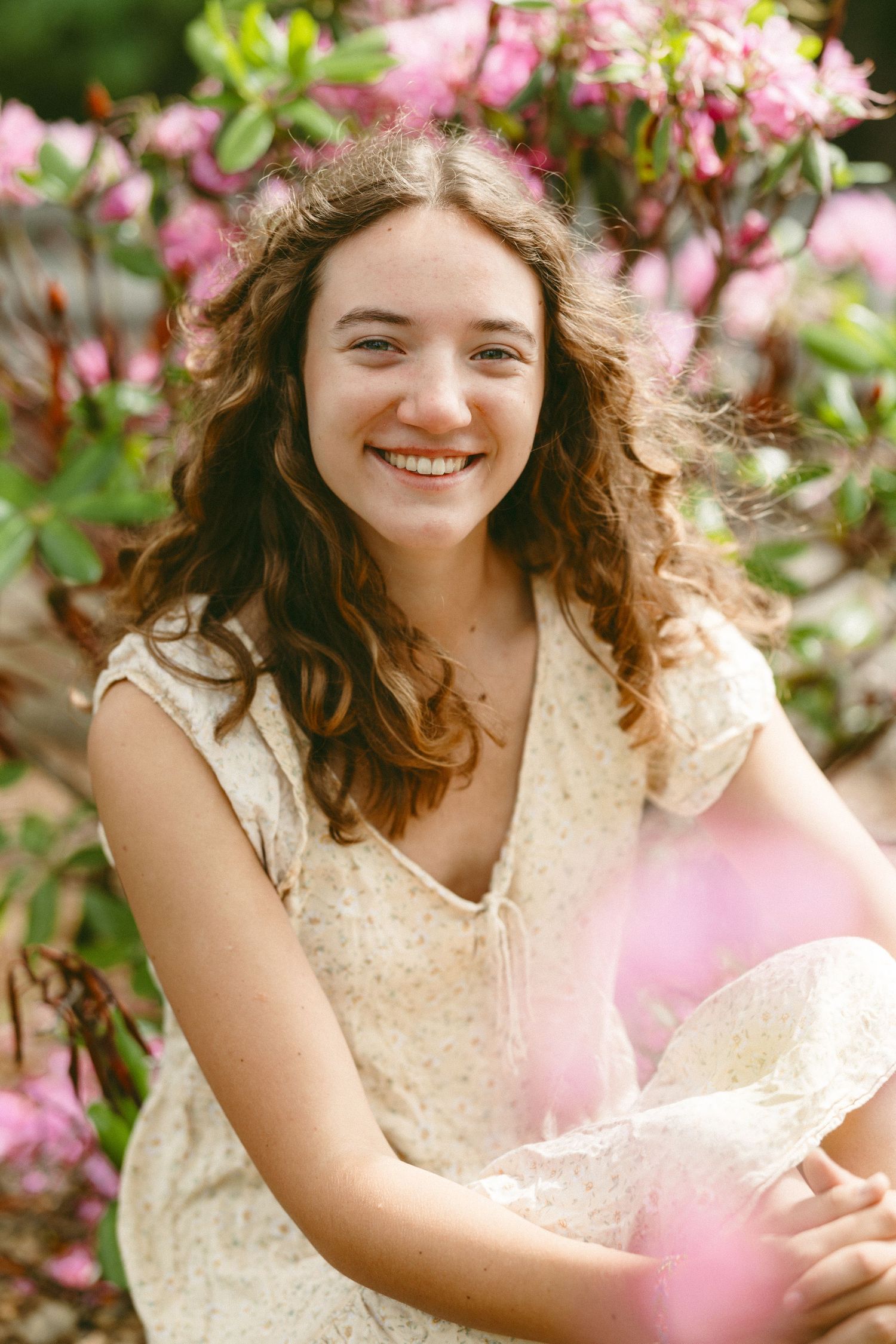 Spring portrait series with pink azalea flowers and someone wearing a cream lace dress.