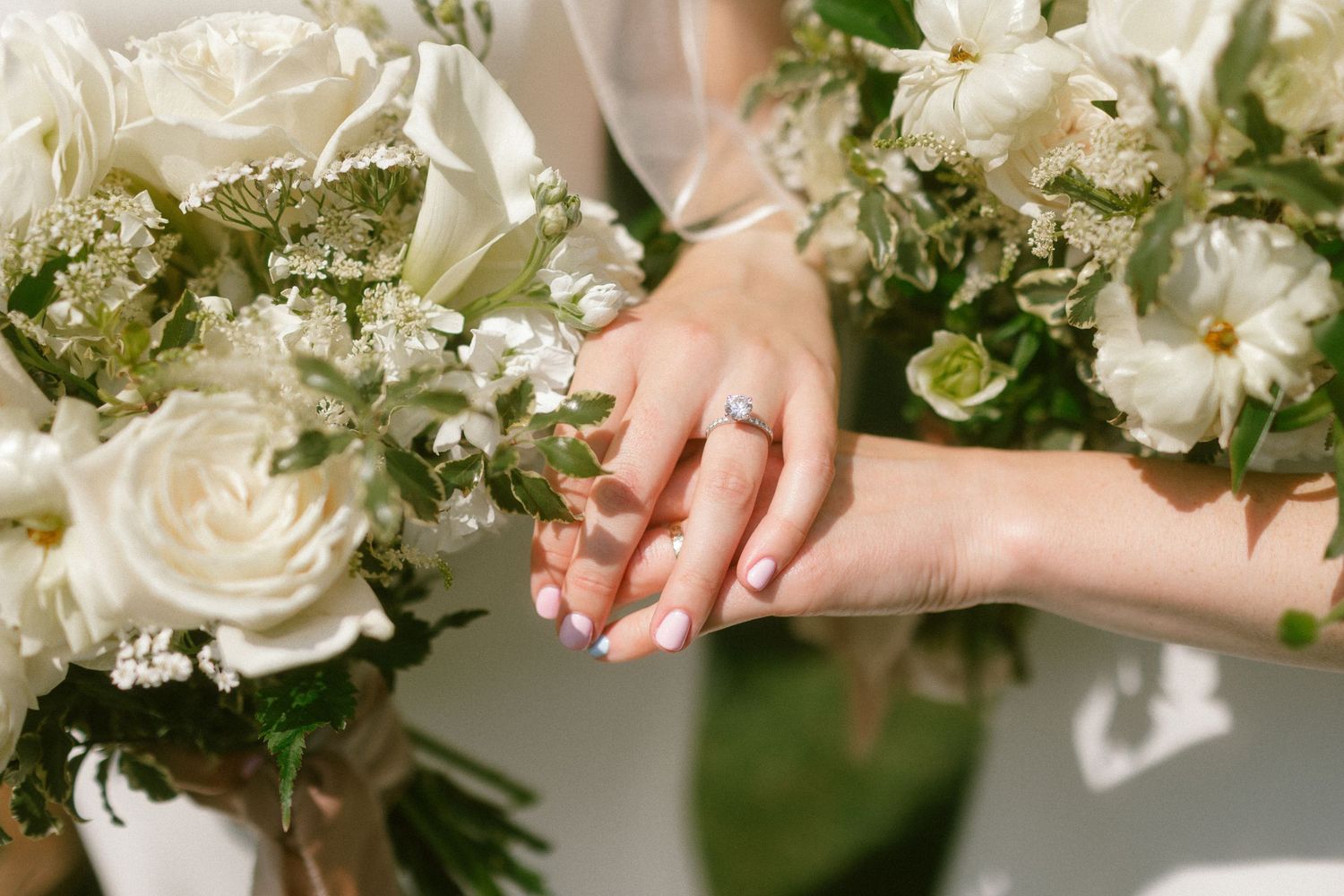 Delicate white floral bouquet with roses and greenery arranged for a wedding.