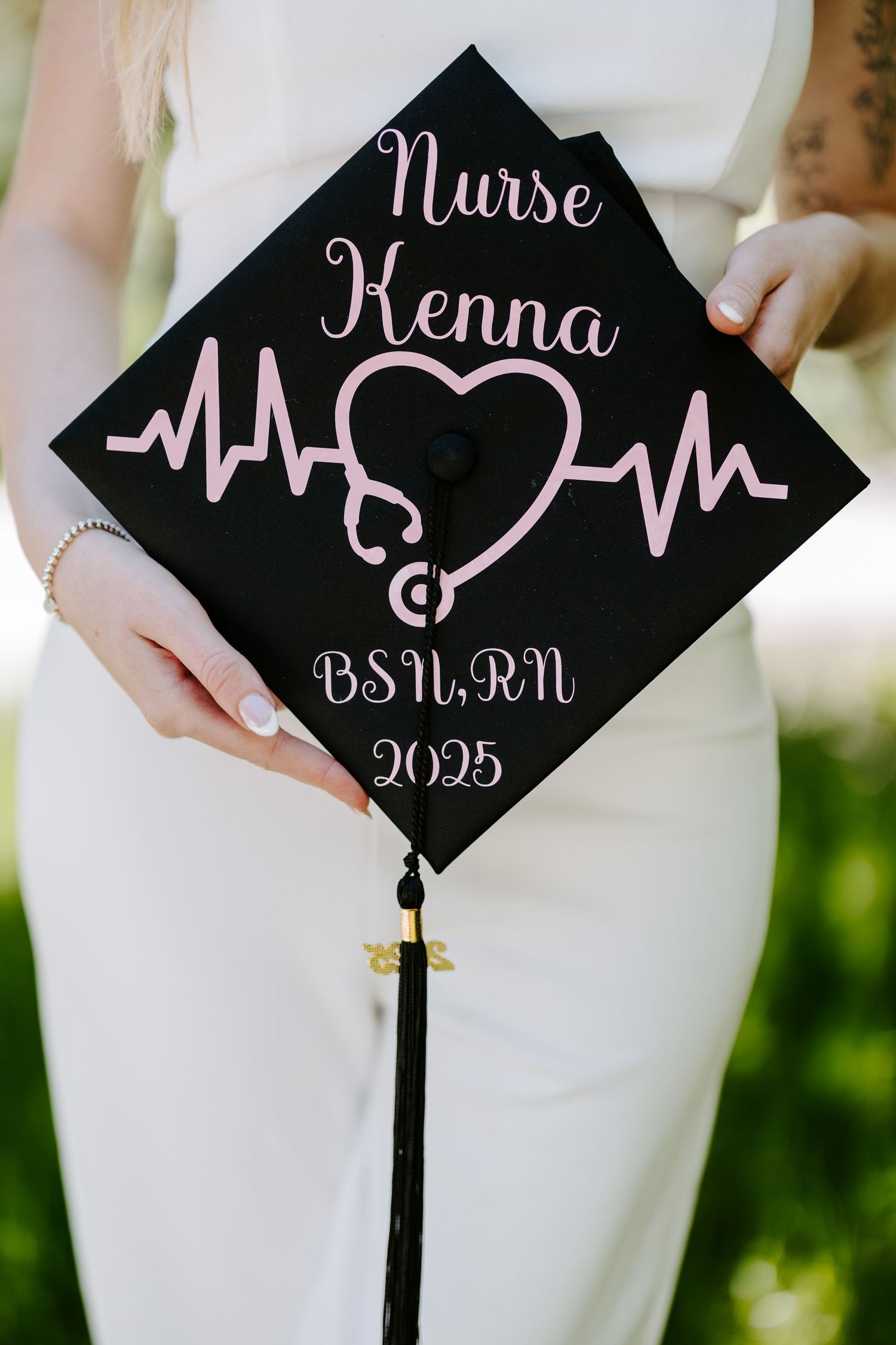 Decorated nursing graduation cap with pink heartbeat design and 2023 graduation year.