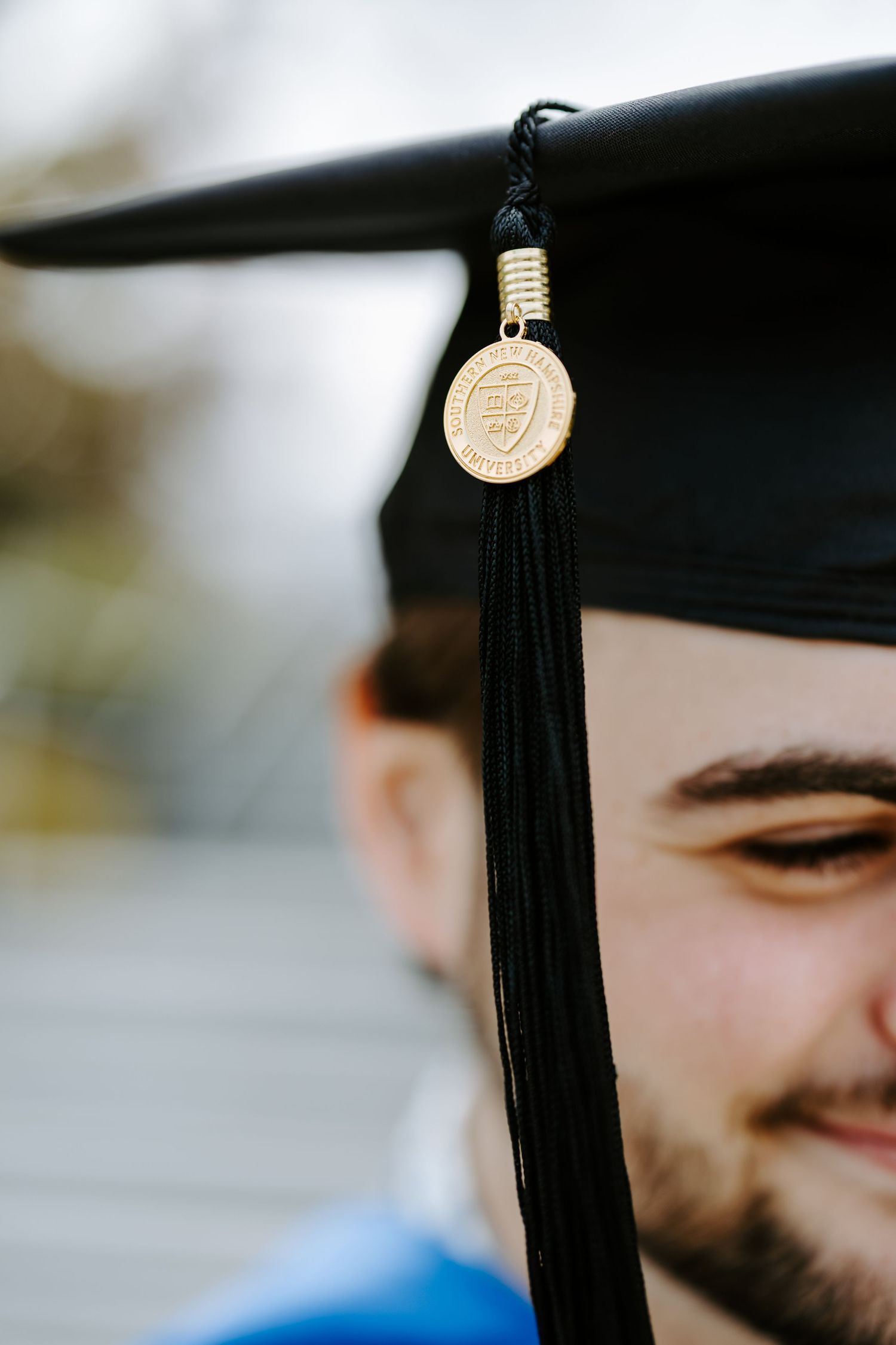 Close-up detail of graduation cap tassels against blurred background.