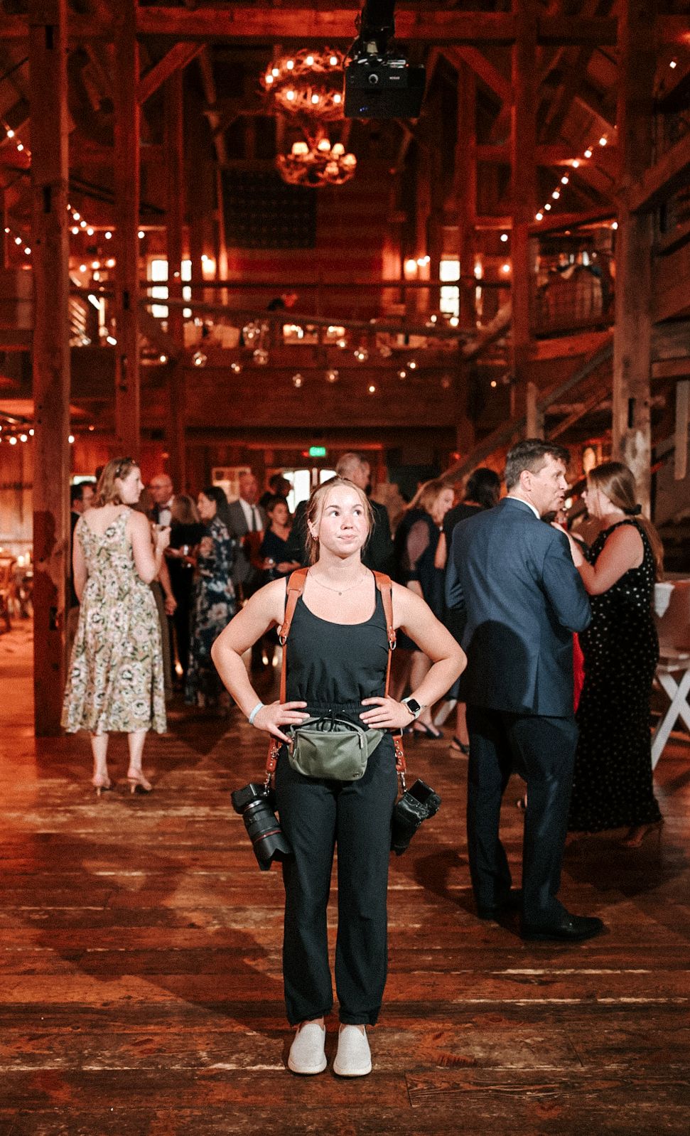 Indoor event space with warm lighting showing people gathered in a rustic warehouse setting.