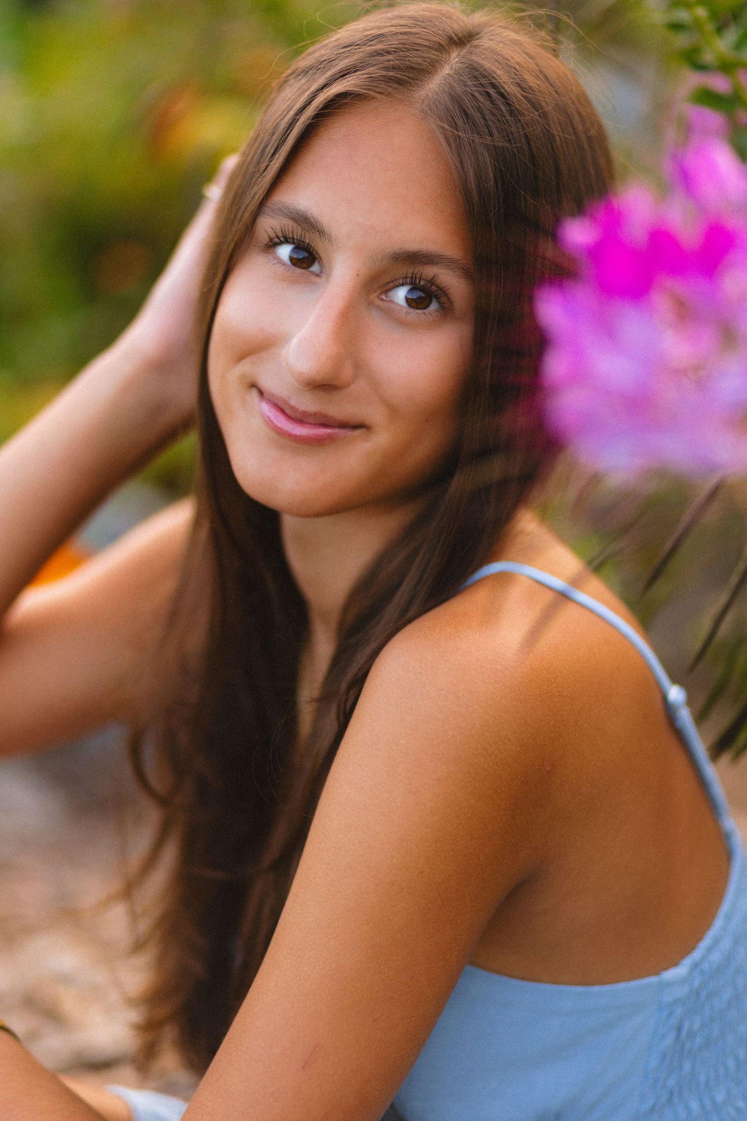Pink flowers provide a vibrant backdrop for a summer portrait in blue.