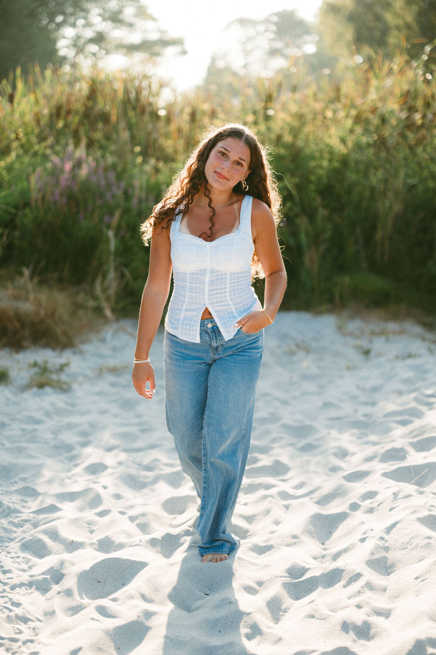 A series of playful poses on a sandy beach with casual summer attire against a natural backdrop.