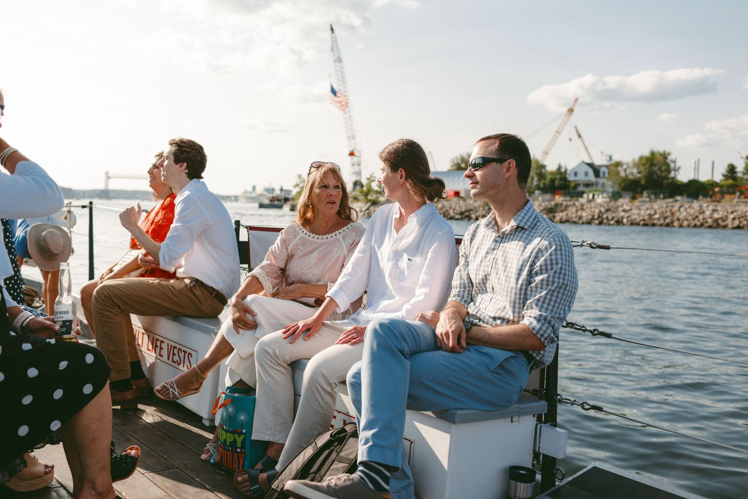 Wedding guests enjoying drinks and conversation on a boat deck.