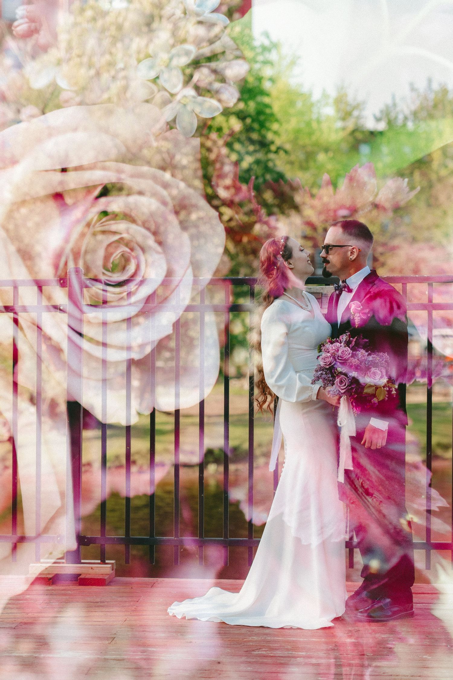 Dreamy double exposure wedding portrait with soft pink roses overlaid on the scene.