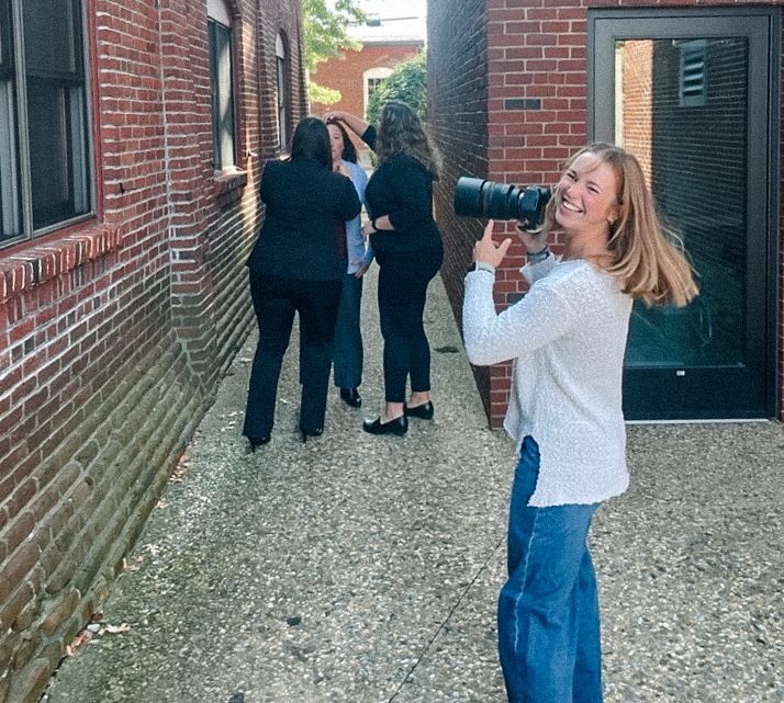 Person in jeans and white shirt poses playfully against a brick wall in a series of casual shots.