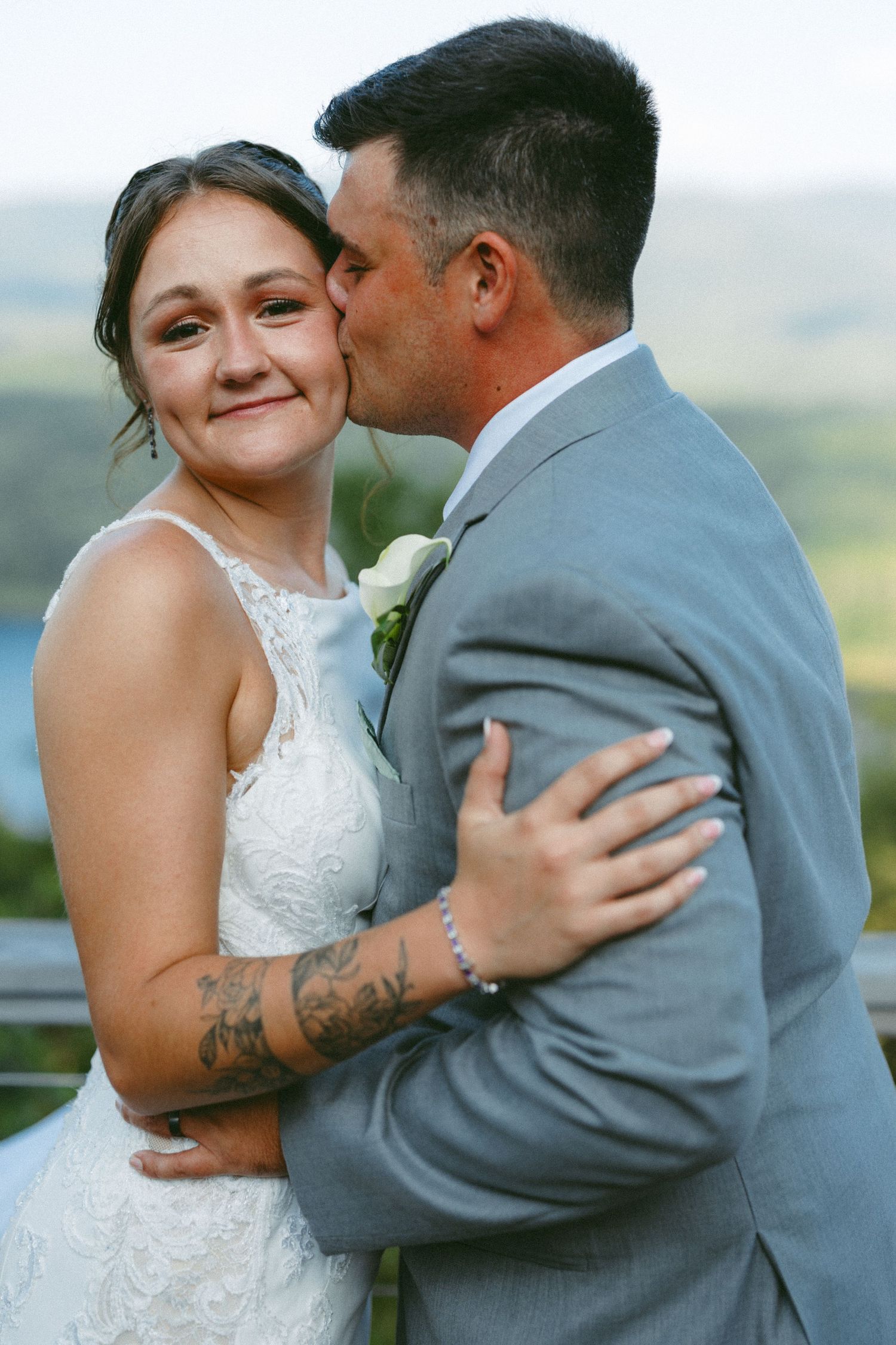 A tender moment between newlyweds against a scenic mountain backdrop.