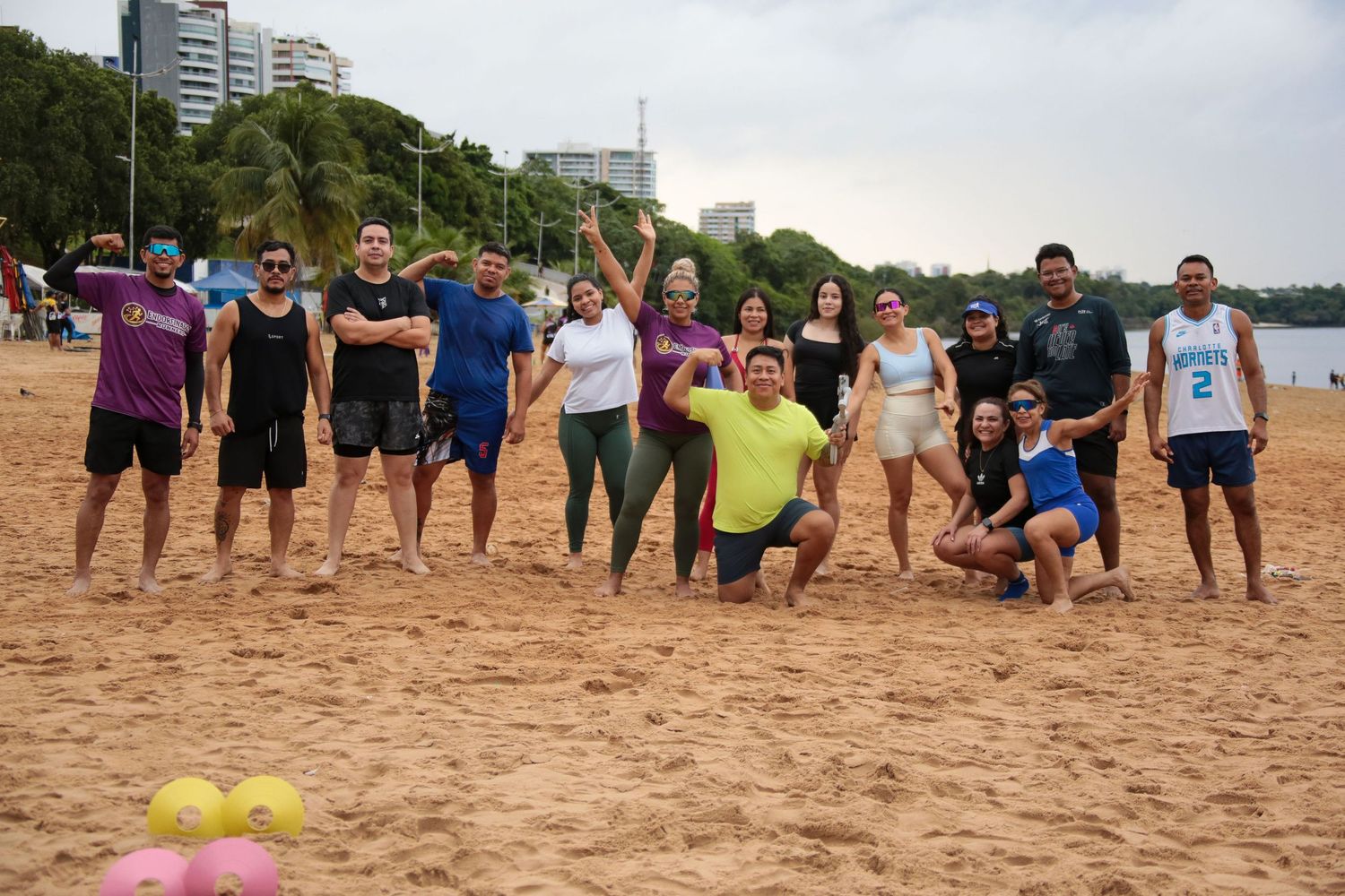 Large group of Endorfinados Runners athletes posing together on a sunny sandy beach.