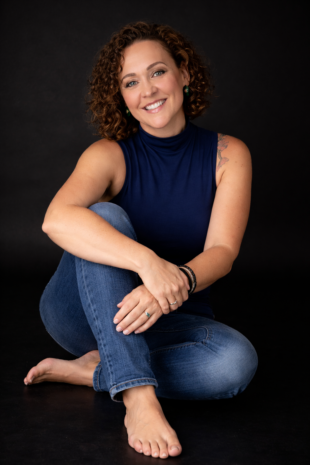 Professional portrait series in casual denim against a dark background showing relaxed poses.