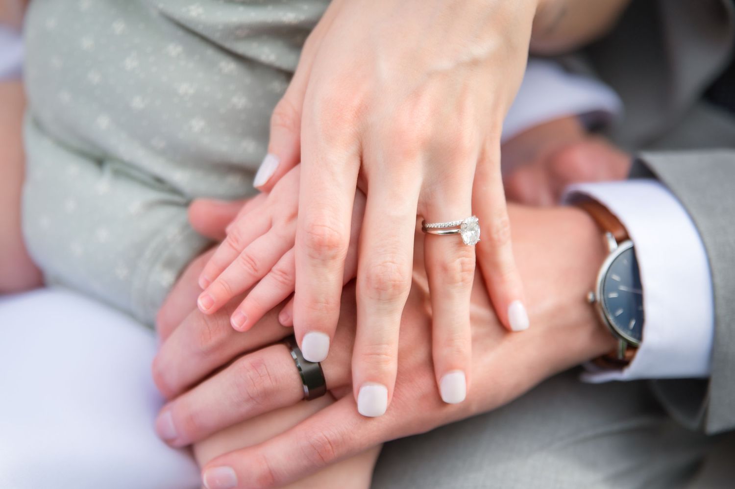 Close-up of hands with wedding rings showing newly married couple.